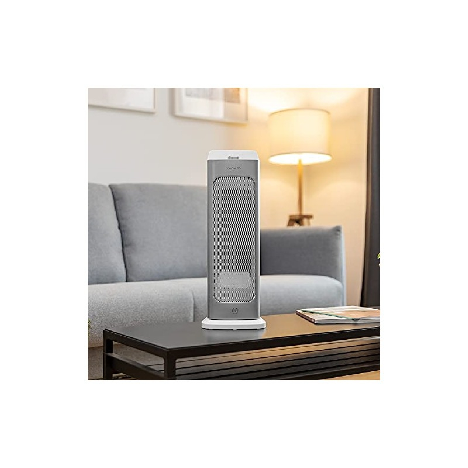 Srebrno-biały grzejnik stoi na czarnym stole w salonie.