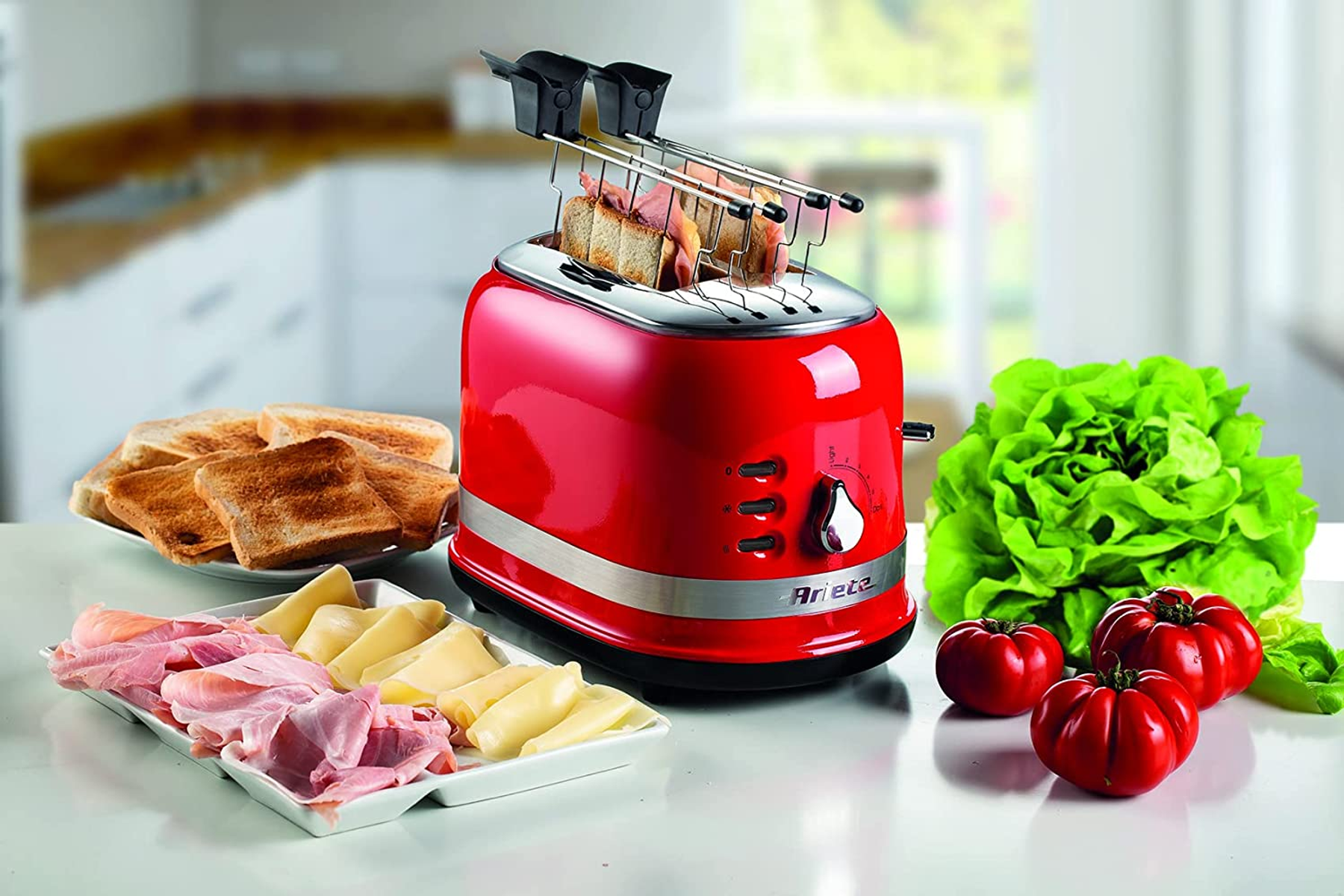 Czerwony toster retro z dwoma kromkami tostów i szynką na stole.