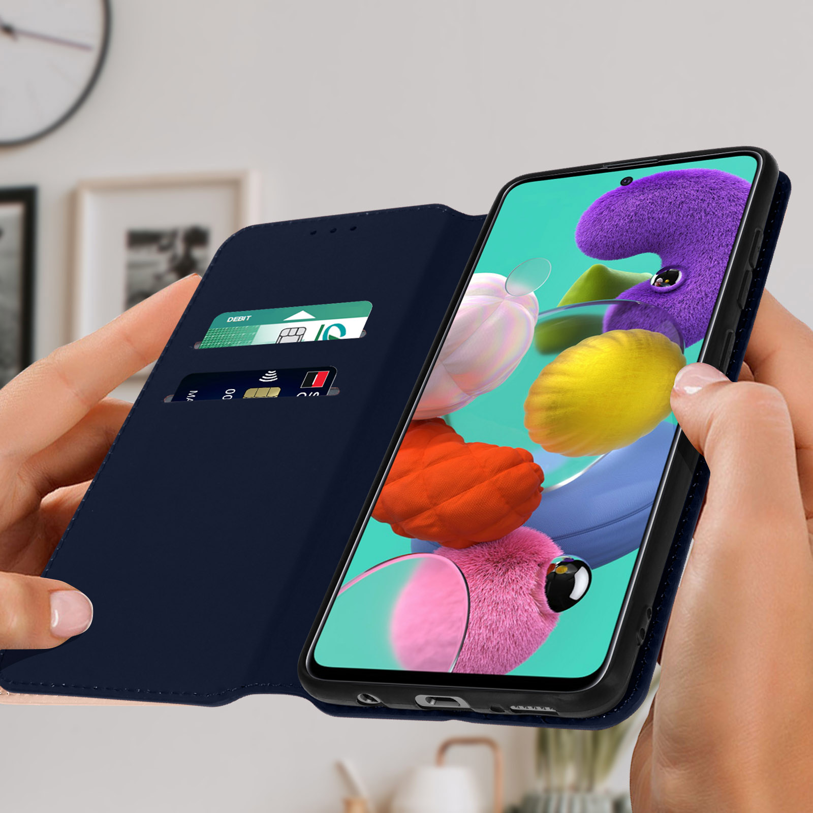 Ein Telefon in einer marineblauen Hülle, geöffnet, zeigt einen bunten Bildschirm. Kreditkarten in der Hülle.