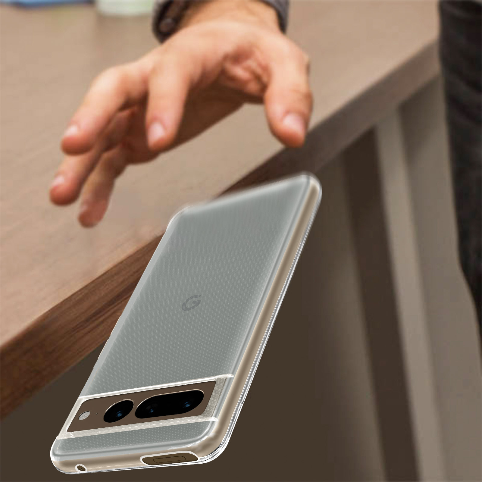 Mano che afferra un telefono in una custodia trasparente. Telefono su un tavolo di legno.