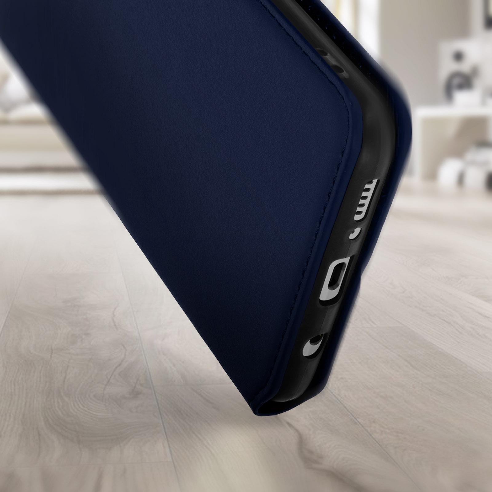Nahaufnahme einer dunkelblauen Handyhülle mit Handy darin, auf Holzoberfläche.