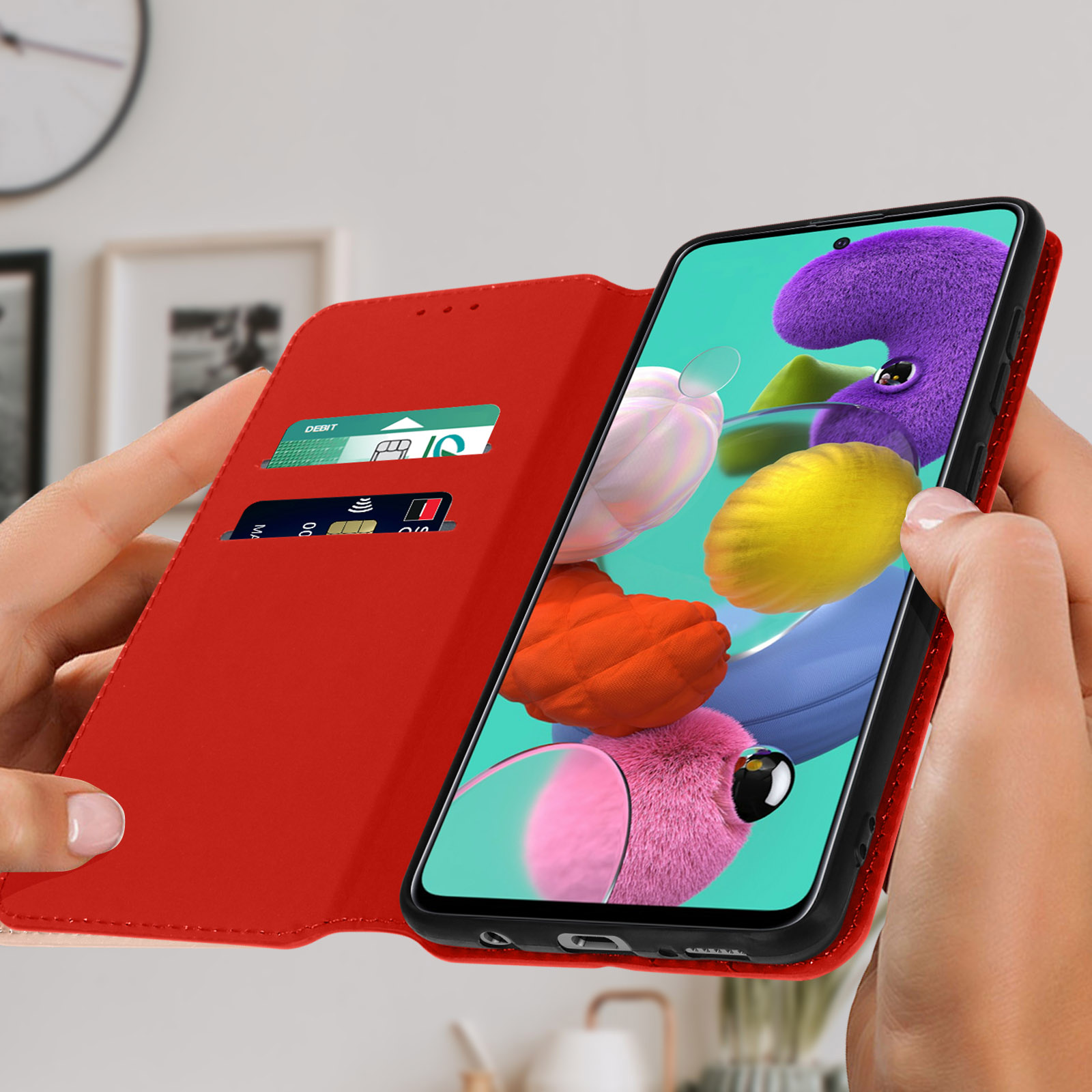 Eine Person hält eine offene rote Handyhülle mit Karten und einem Handy mit Blumen.