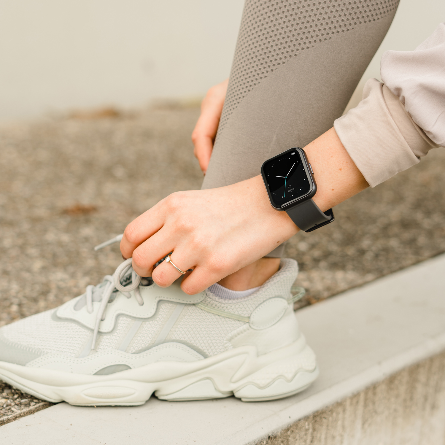 Eine Person trägt eine Smartwatch und Laufschuhe, die sich auf ein Training vorbereitet.