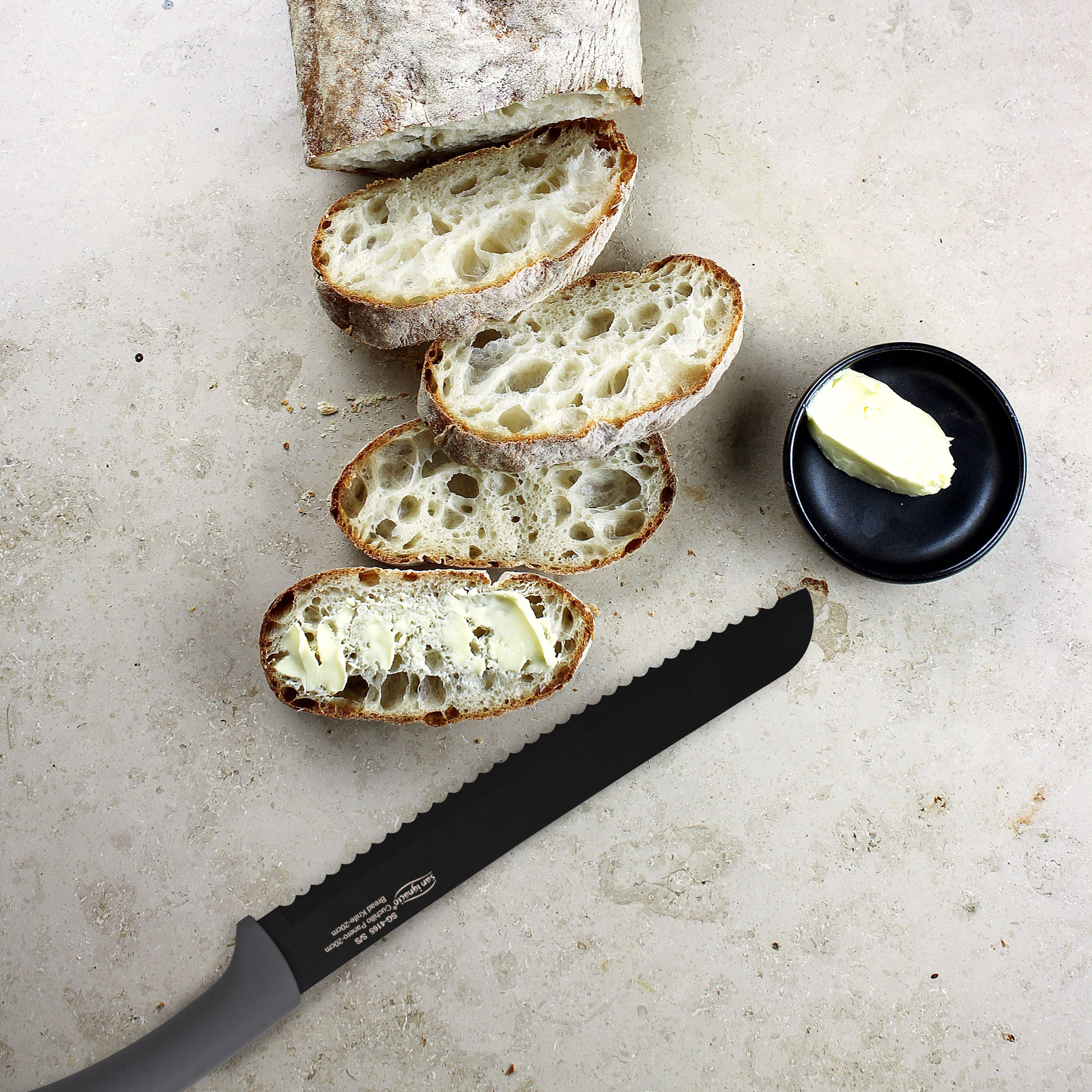 Rebanadas de pan con mantequilla, un cuchillo y un plato pequeño de mantequilla.