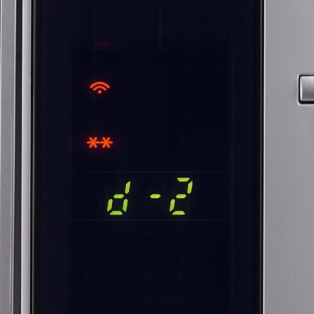 Zbliżenie wyświetlacza kuchenki mikrofalowej. Widoczne zielone cyfry i symbole.