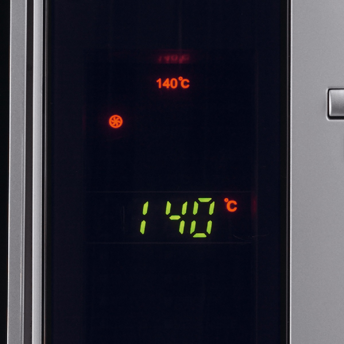 Zbliżenie wyświetlacza kuchenki mikrofalowej pokazujące 140 stopni Celsjusza.