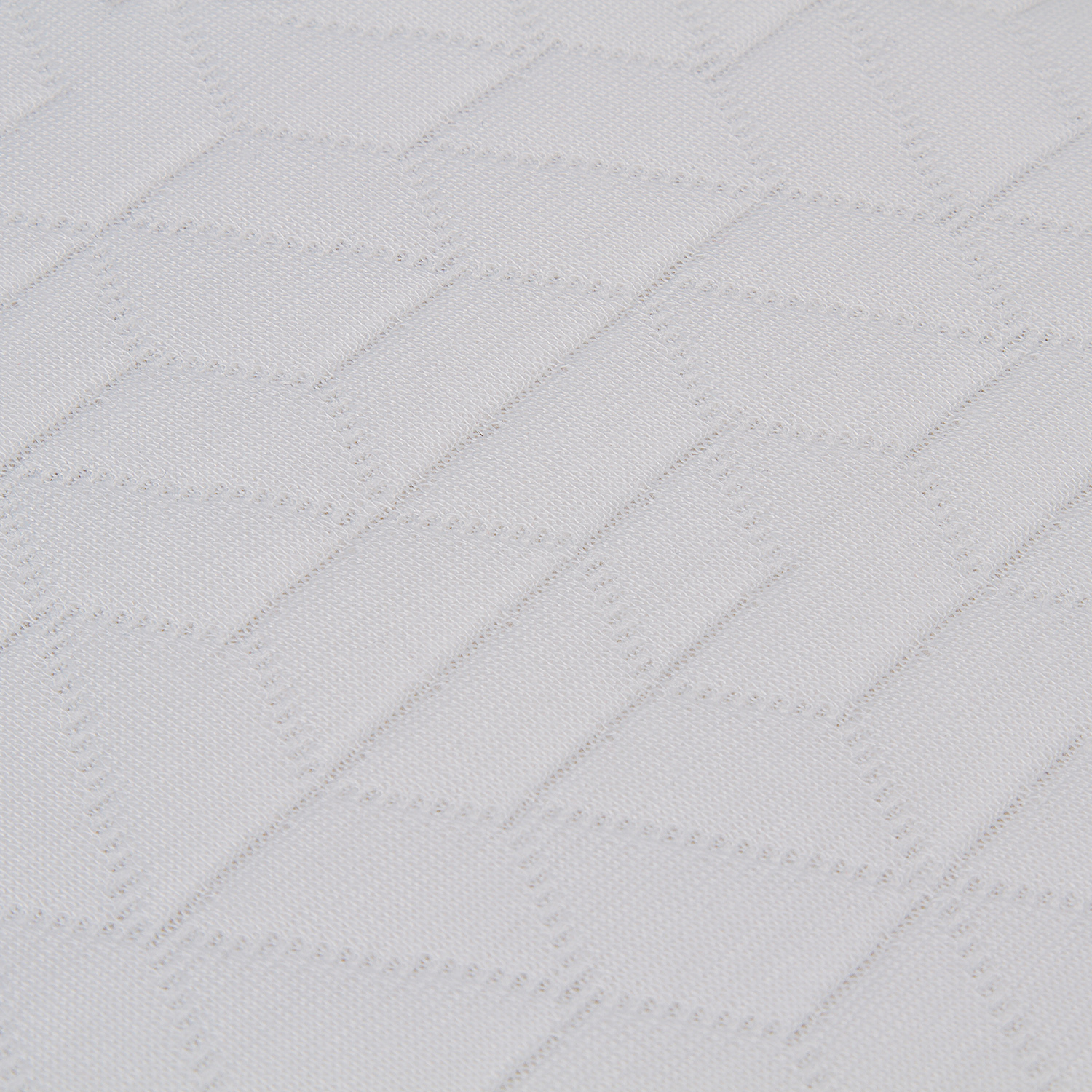 Primer plano de un colchón blanco con un patrón geométrico.