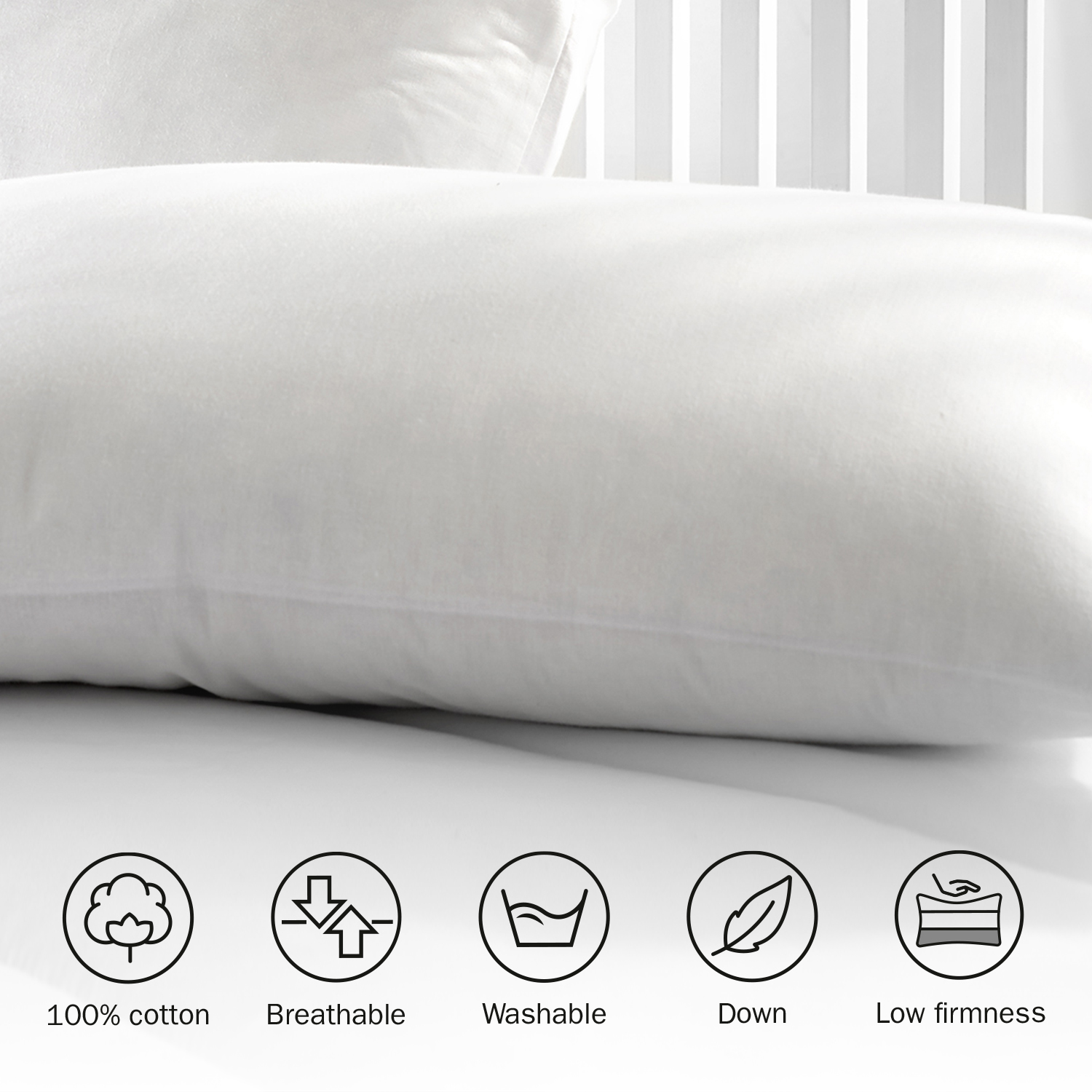 Primer plano de una almohada blanca con iconos que indican que es 100% algodón, transpirable, lavable, plumón y de baja firmeza.