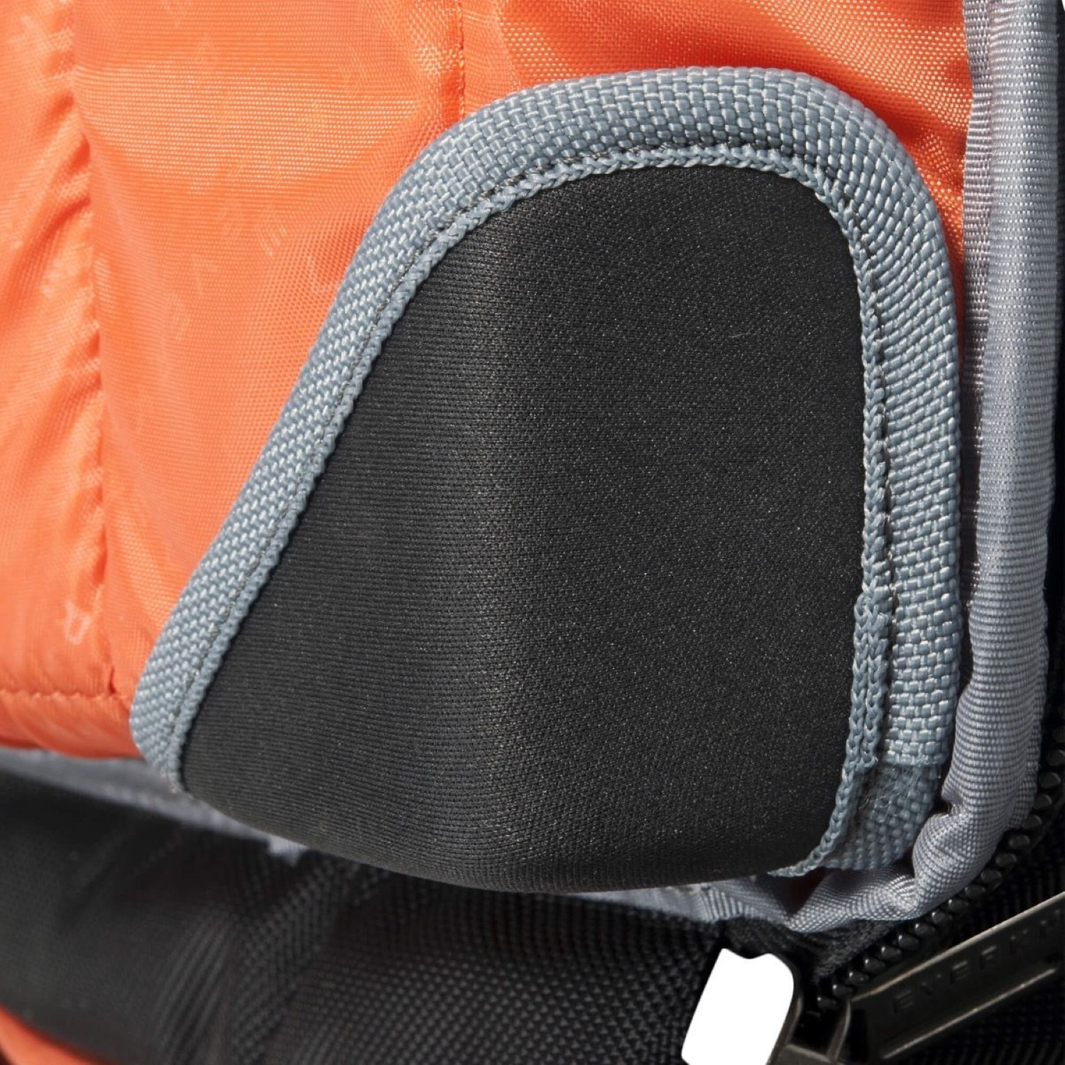 Detail eines orangefarbenen und schwarzen Rucksacks. Der Rucksack hat einen gepolsterten schwarzen Bereich.