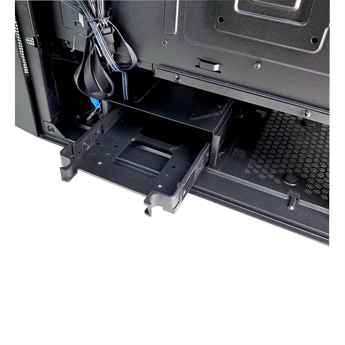 Interieur van een computerkast met de drive bay en enkele kabels, tegen een witte achtergrond.