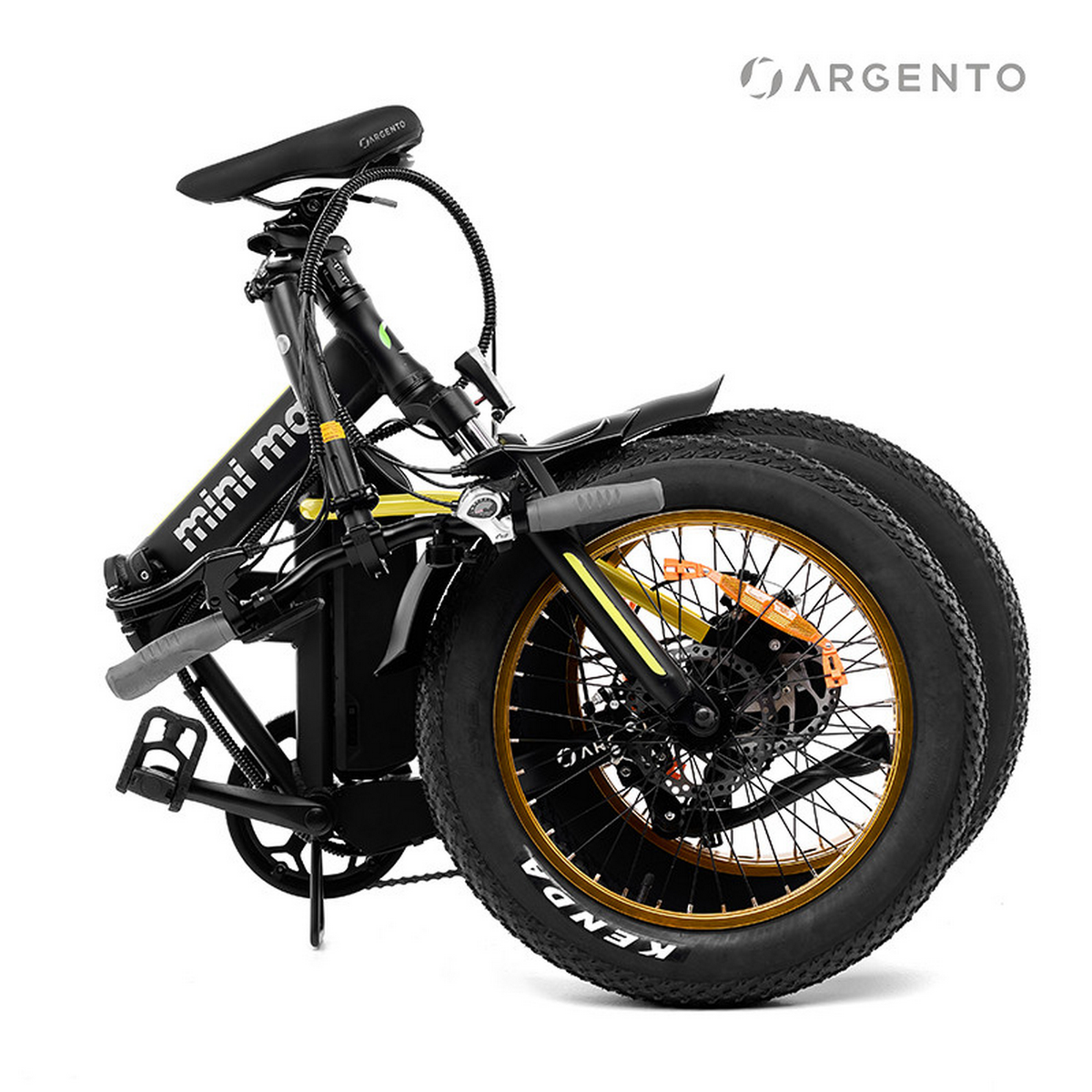 Bicicletta elettrica pieghevole. Telaio nero con accenti dorati. Le ruote sono grandi e larghe.