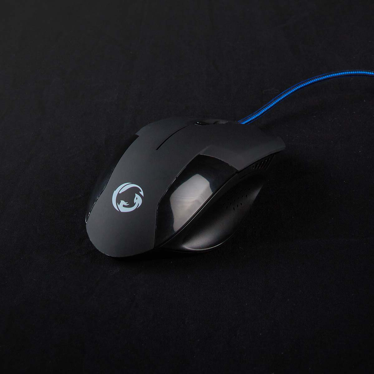Schwarze Computermaus mit blauem Kabel, auf schwarzer Oberfläche.