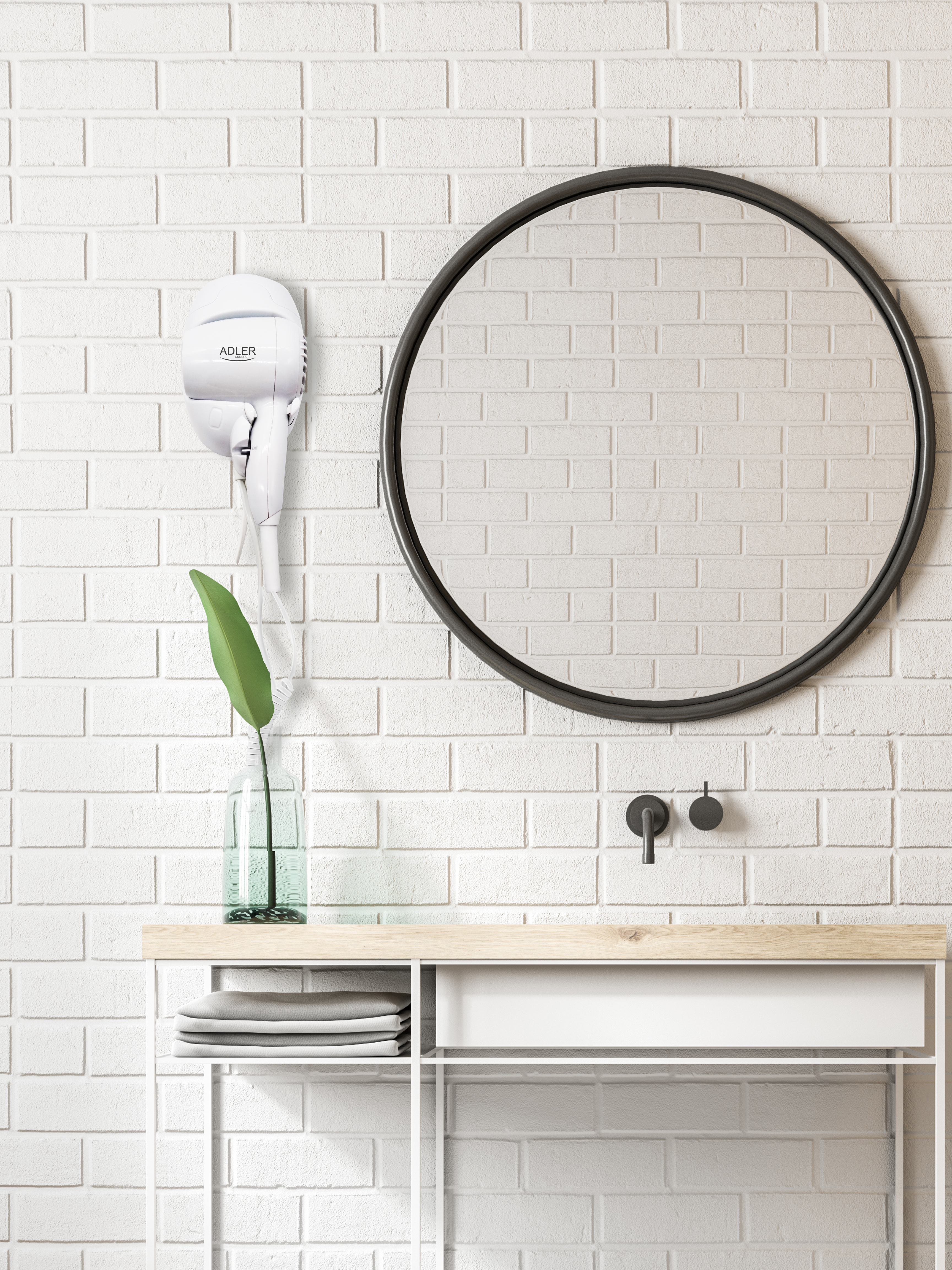 Een witte haardroger aan een witte muur naast een ronde spiegel en een plank met items.