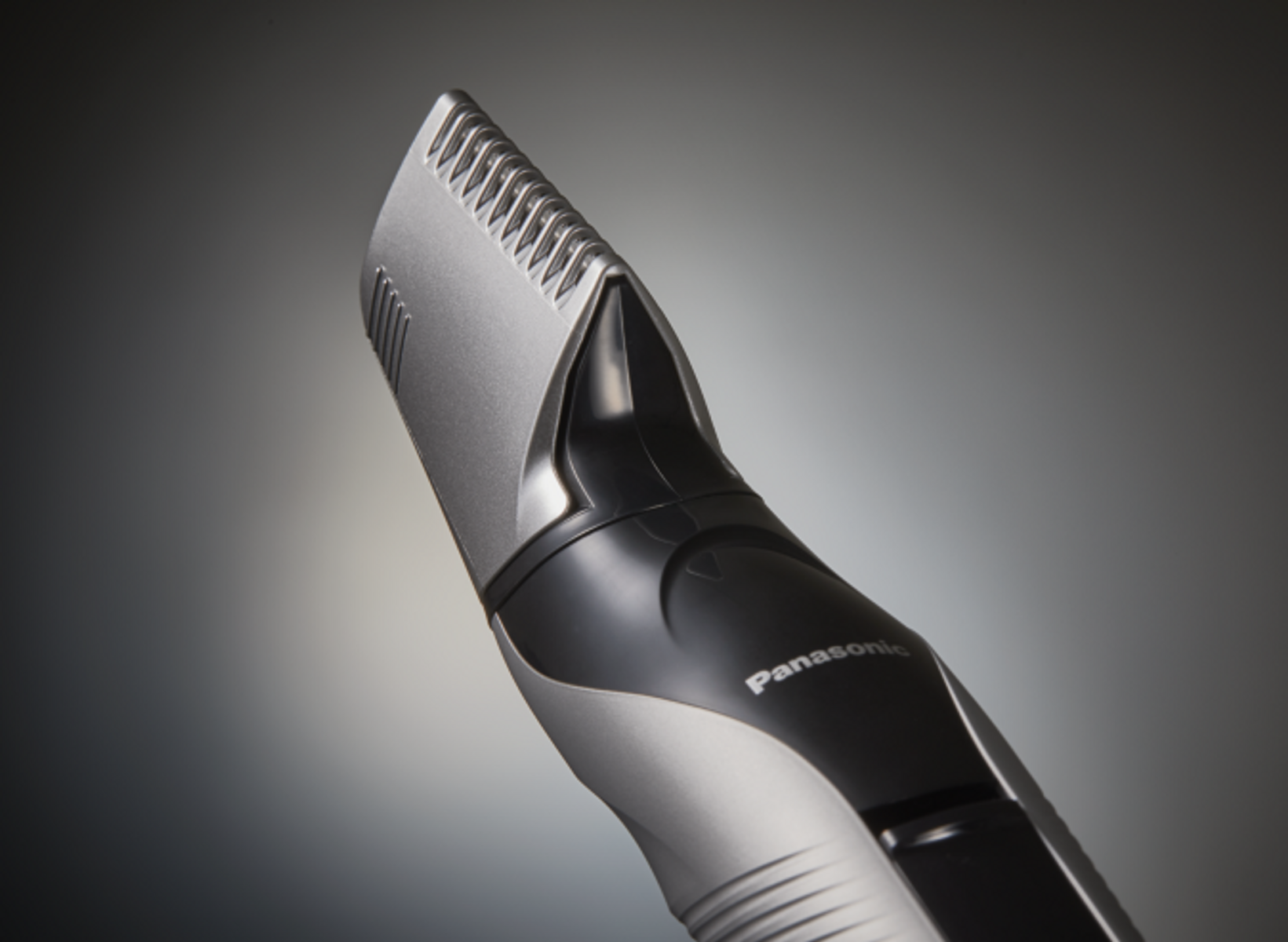 Nahaufnahme eines Panasonic Bartschneiders mit grauem und schwarzem Design, vor grauem Hintergrund.
