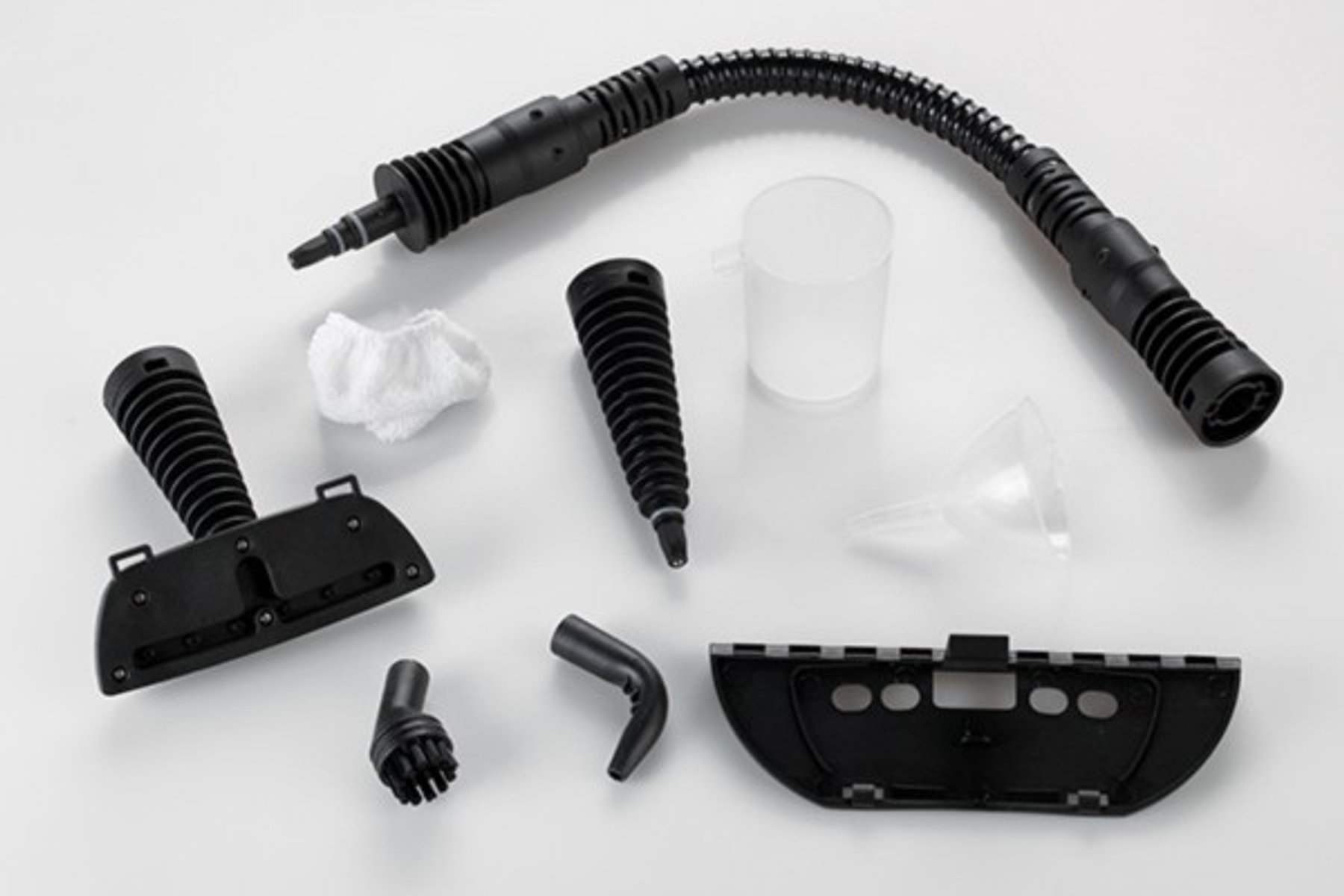 Zestaw czarnych przystawek do czyszczenia parą na białej powierzchni.