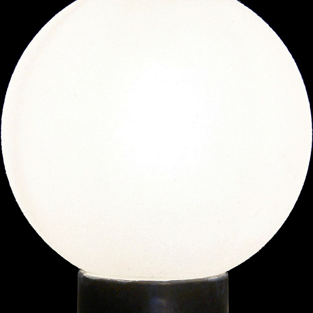 Primer plano de una lámpara globo blanca esmerilada con una base negra sobre fondo negro.