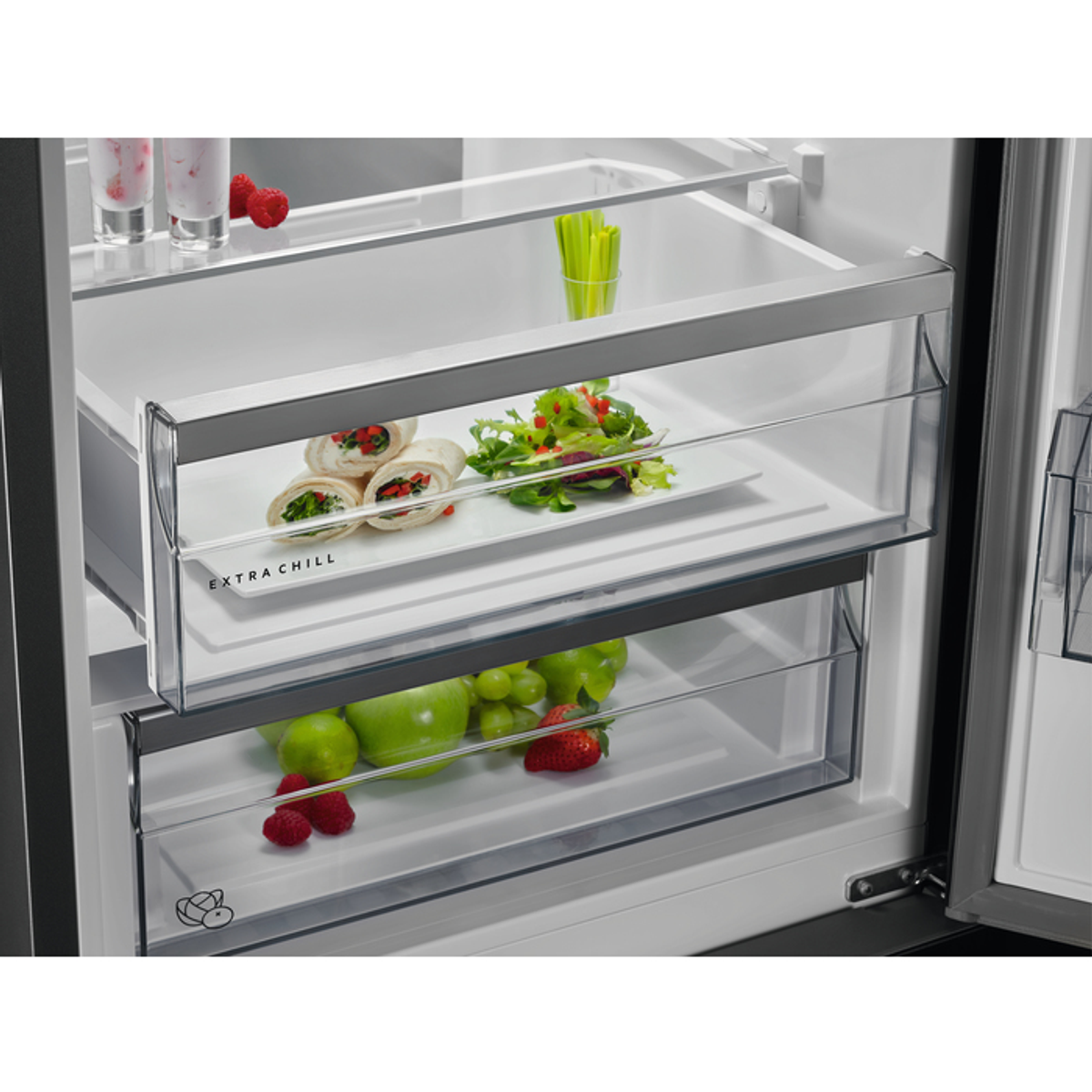 Cajones de refrigerador con comida: wraps, ensalada, manzanas verdes, fresas y uvas.