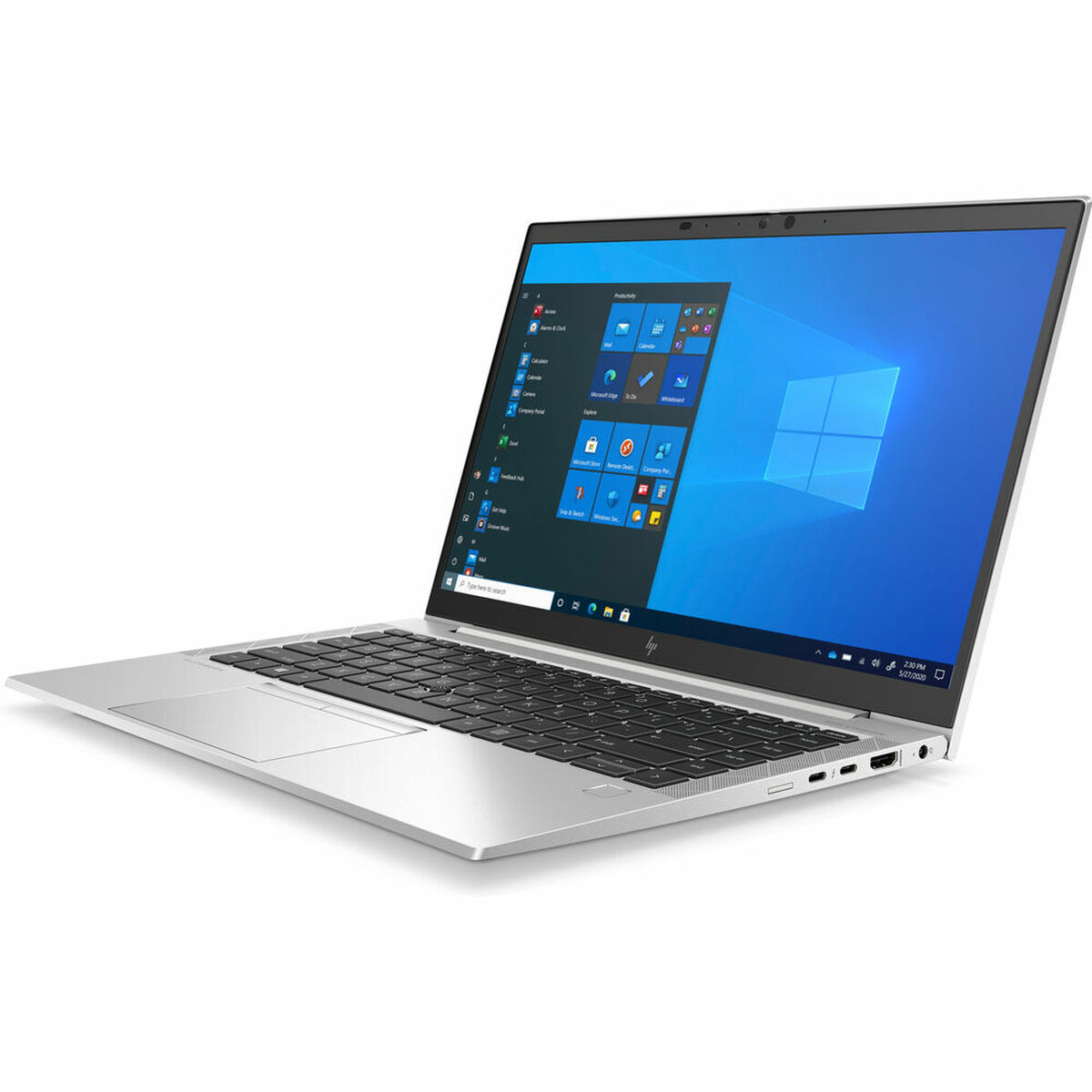 Una computadora portátil plateada, abierta, sobre una superficie blanca, en ángulo a la izquierda.