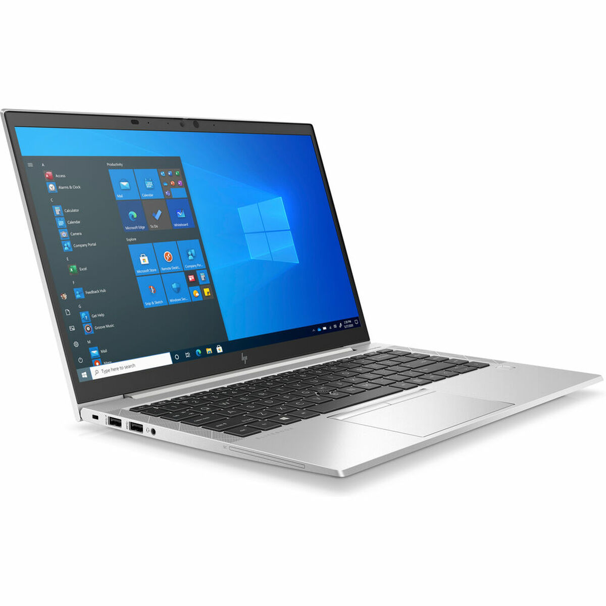 Un portátil plateado, abierto, sobre un fondo blanco. Muestra el escritorio de Windows.
