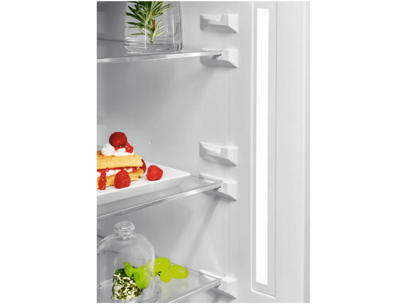 Wnętrze lodówki z półkami i jedzeniem, oświetlone pionowym paskiem światła.