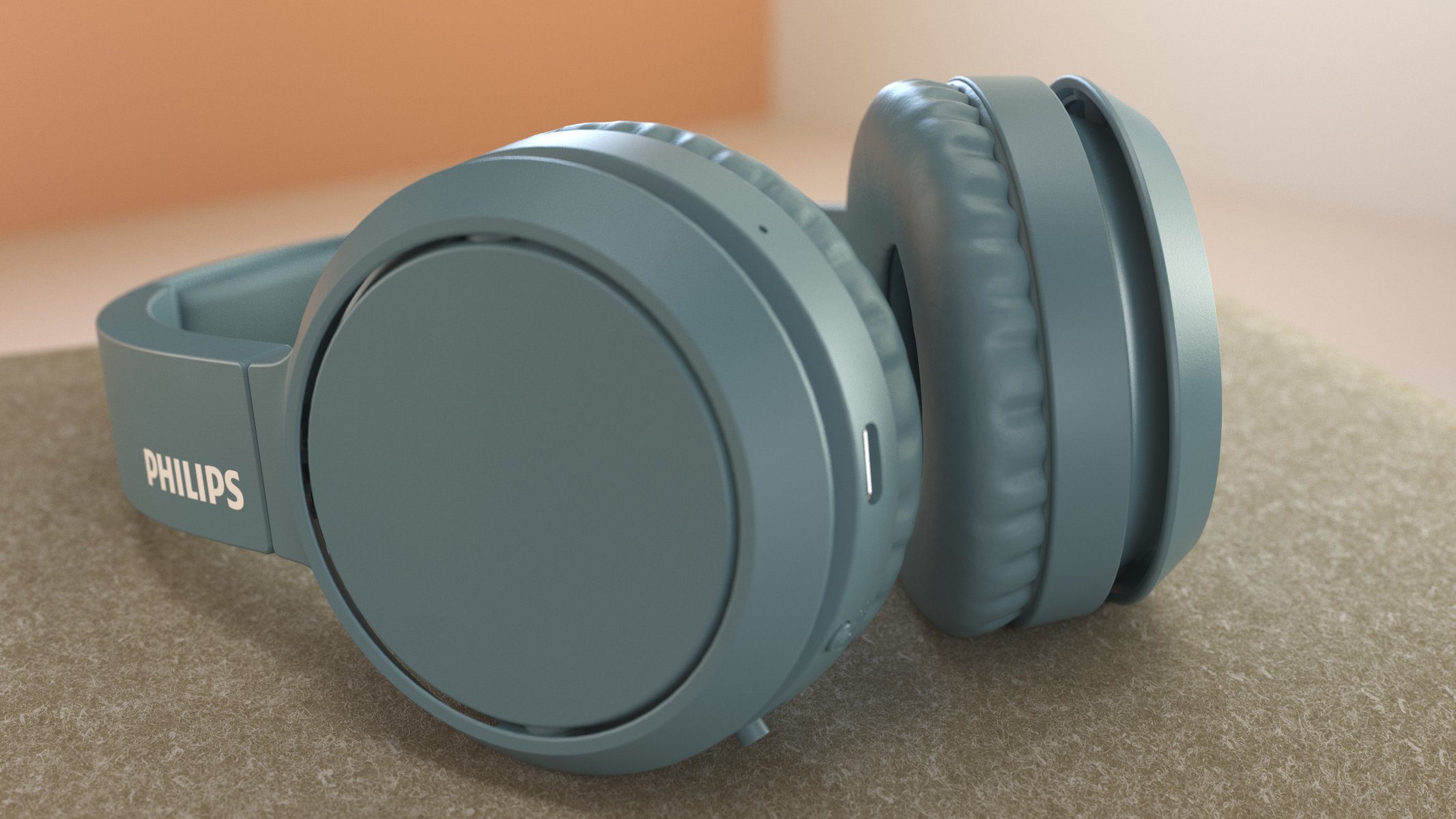 Auriculares azules sobre una superficie suave. El auricular izquierdo muestra la marca PHILIPS.