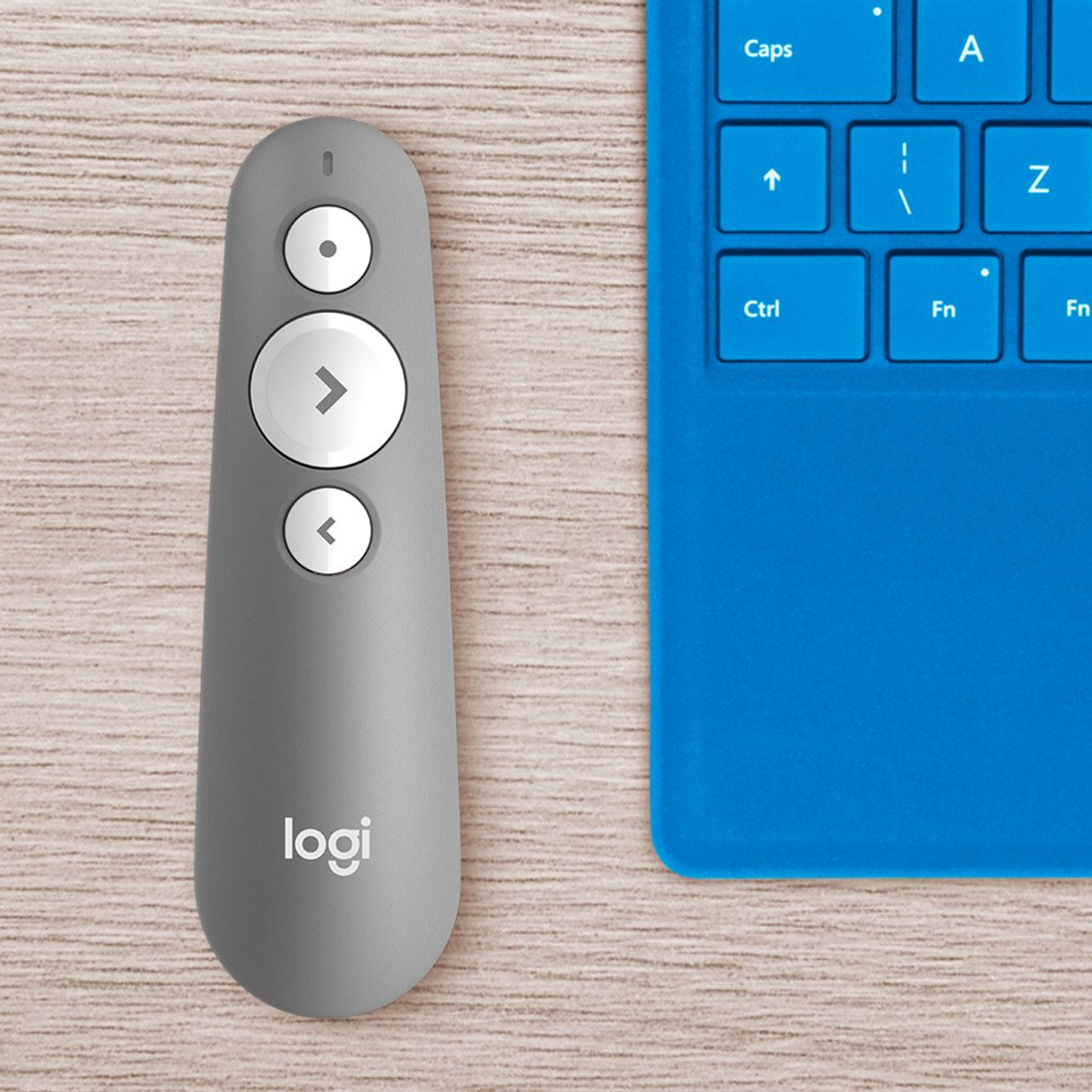 Szary pilot do prezentacji z przyciskami i logo, obok niebieskiej klawiatury.