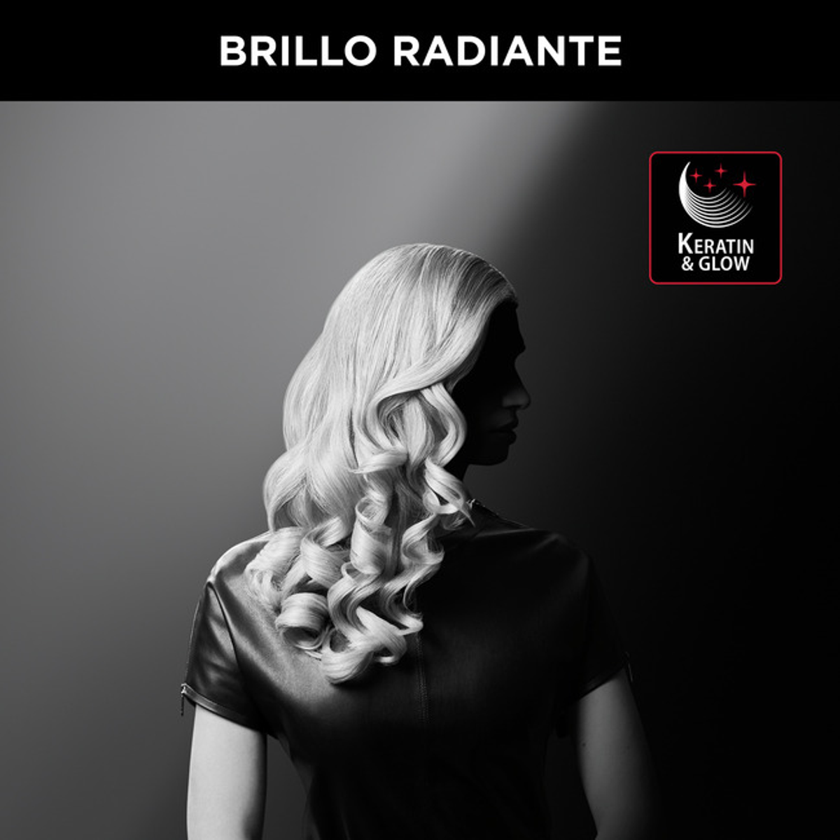 Donna con capelli biondi ricci, giacca di pelle nera. Sfondo nero.