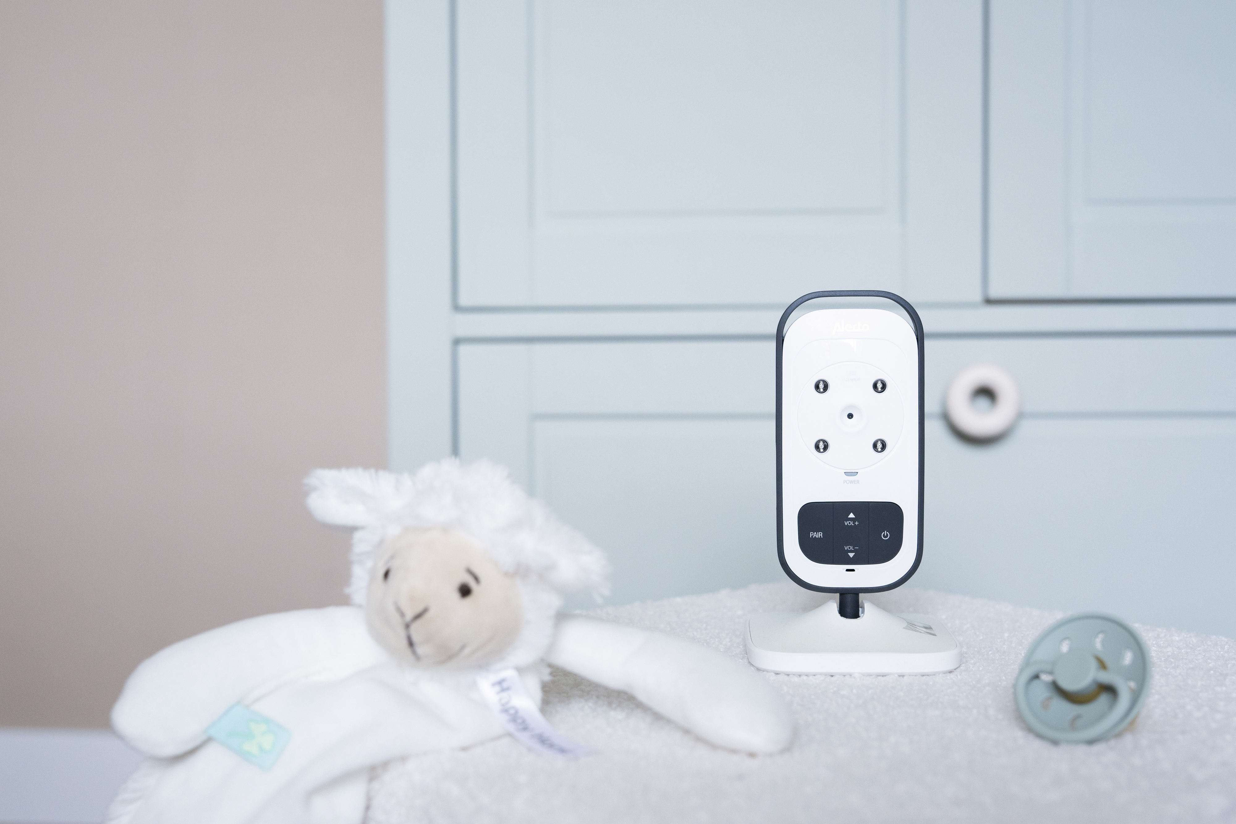 Zestaw niani elektronicznej z zabawką owcą i smoczkiem.