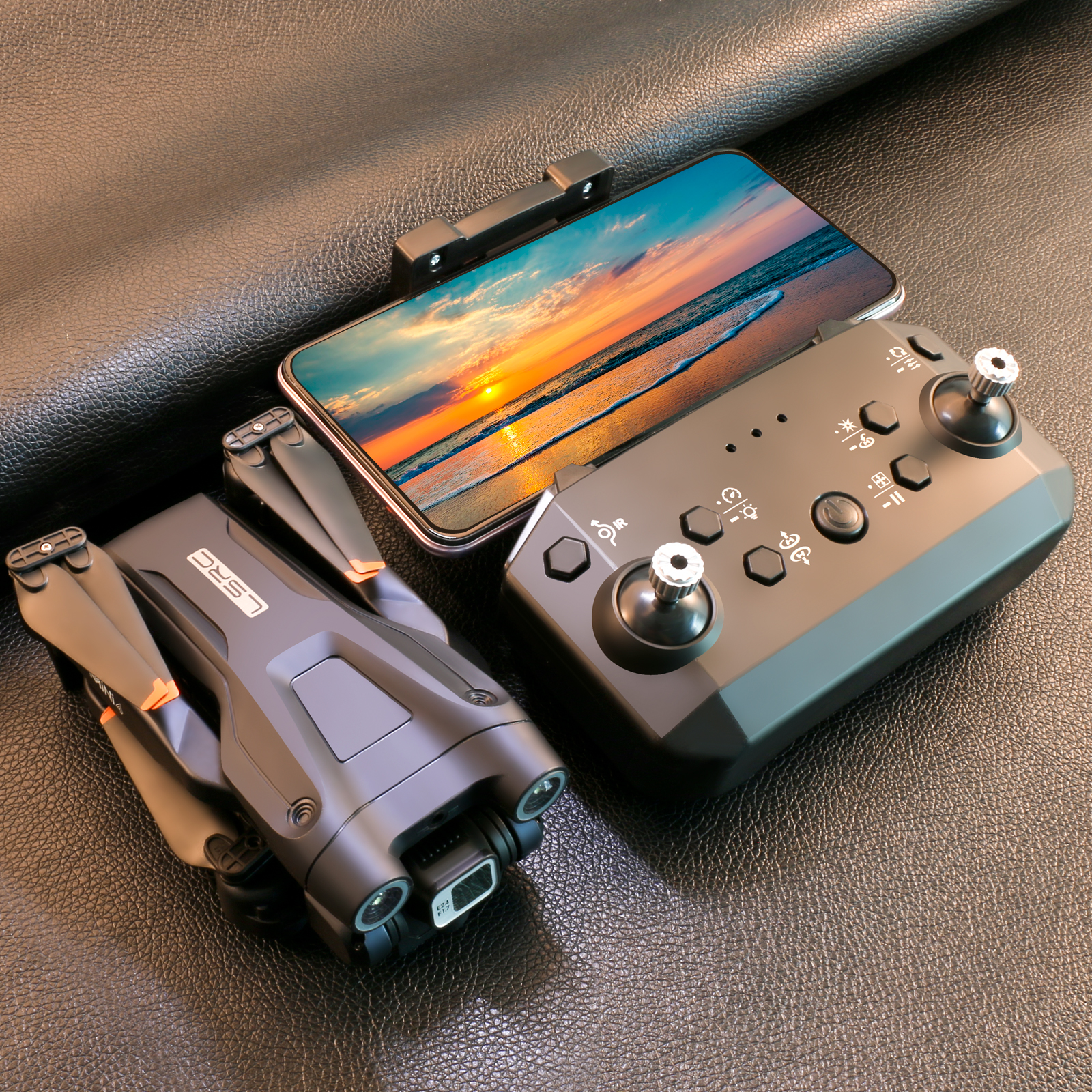 Drohne, Telefon und Controller auf Leder, Drohne ist schwarz.