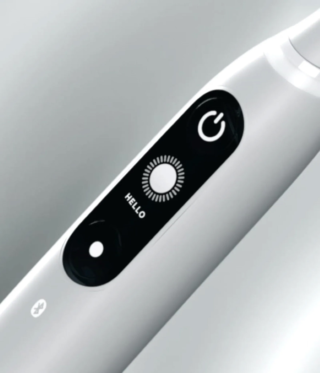 Biała szczoteczka do zębów z przyciskiem zasilania i wyświetlaczem ustawień.