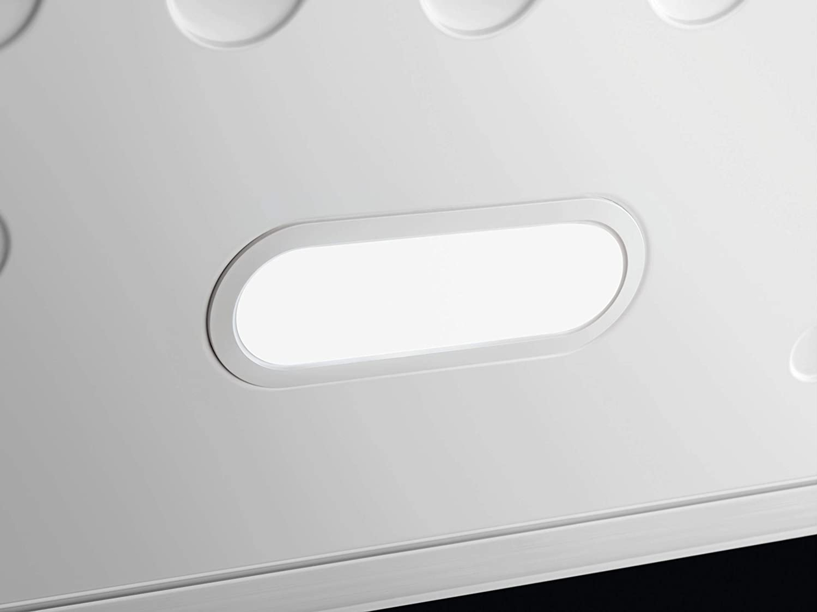 Un soffitto bianco con un apparecchio di illuminazione ovale illuminato.