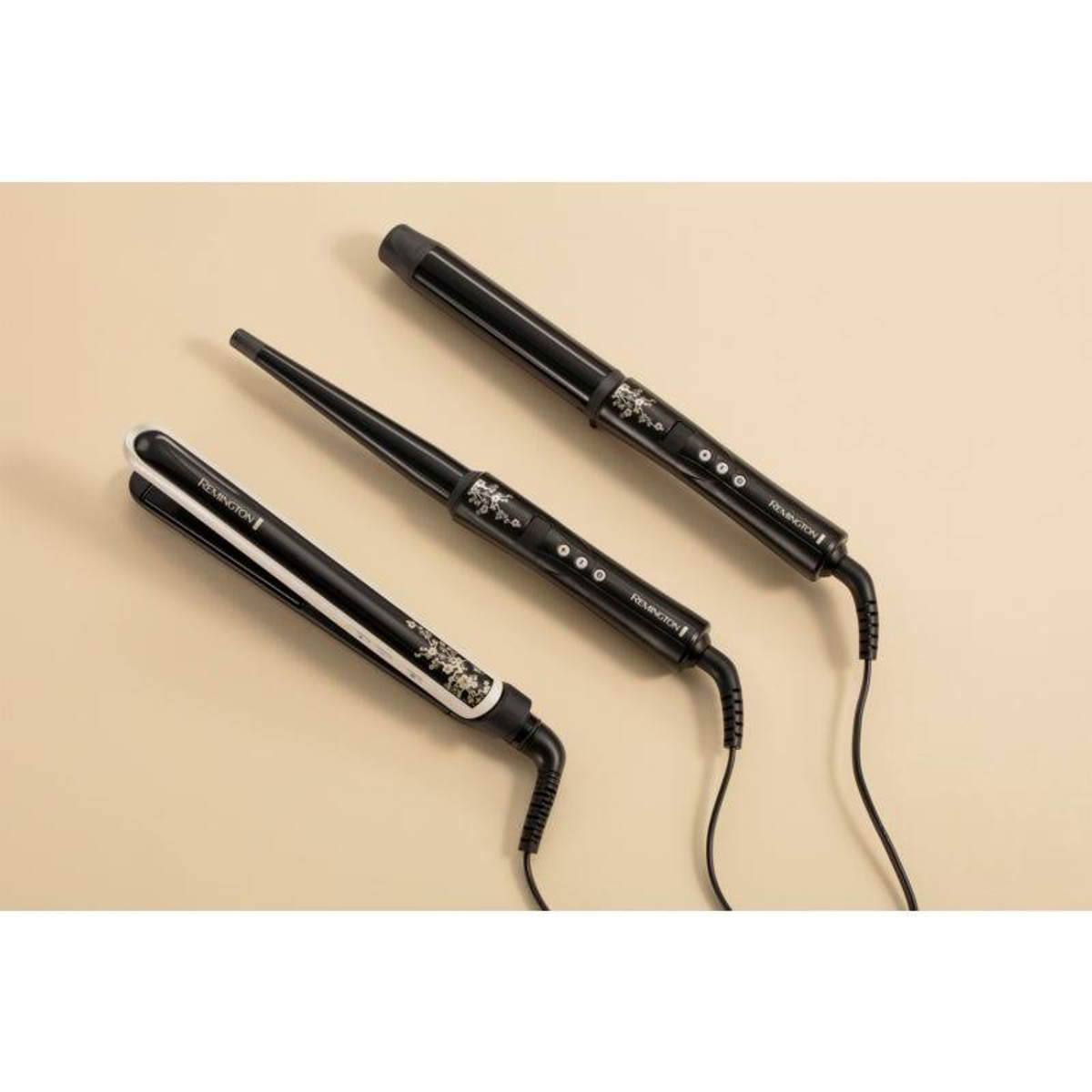 Herramientas negras para peinar el cabello sobre un fondo beige.