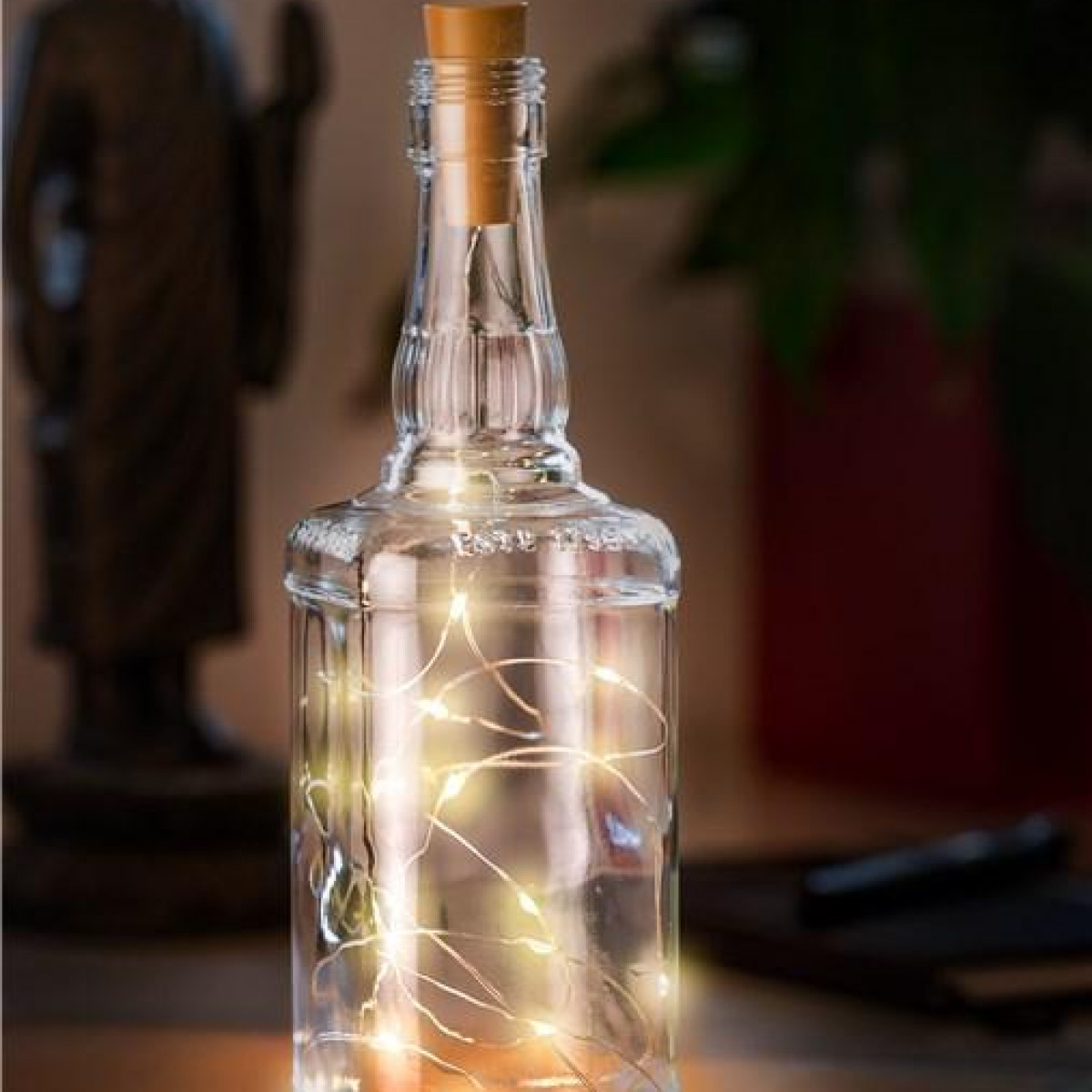 Glasflasche mit Lichterkette und Korken. Lichter sind in der Flasche, erzeugen ein Leuchten.