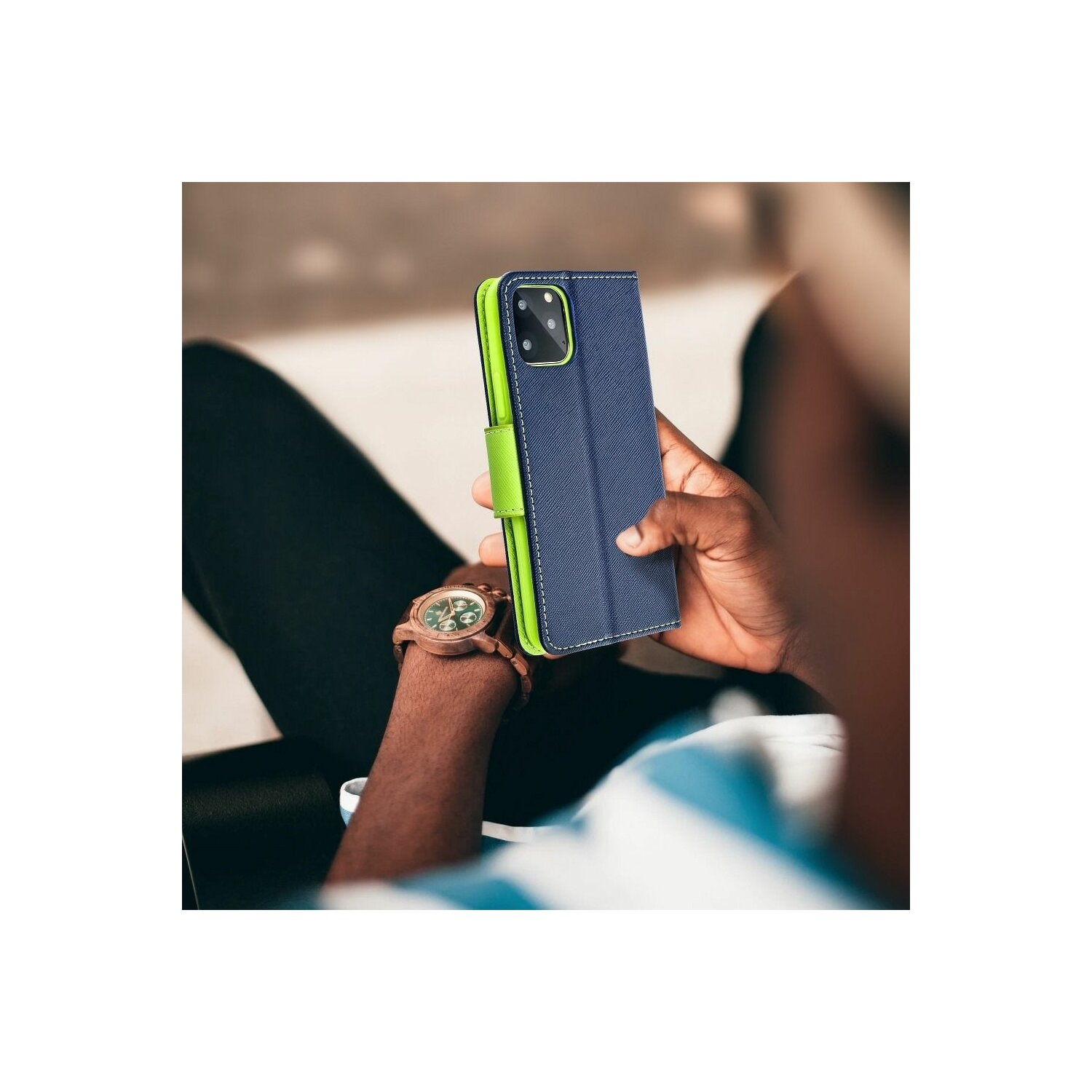 Una persona tiene in mano una custodia blu per telefono con rivestimento verde.