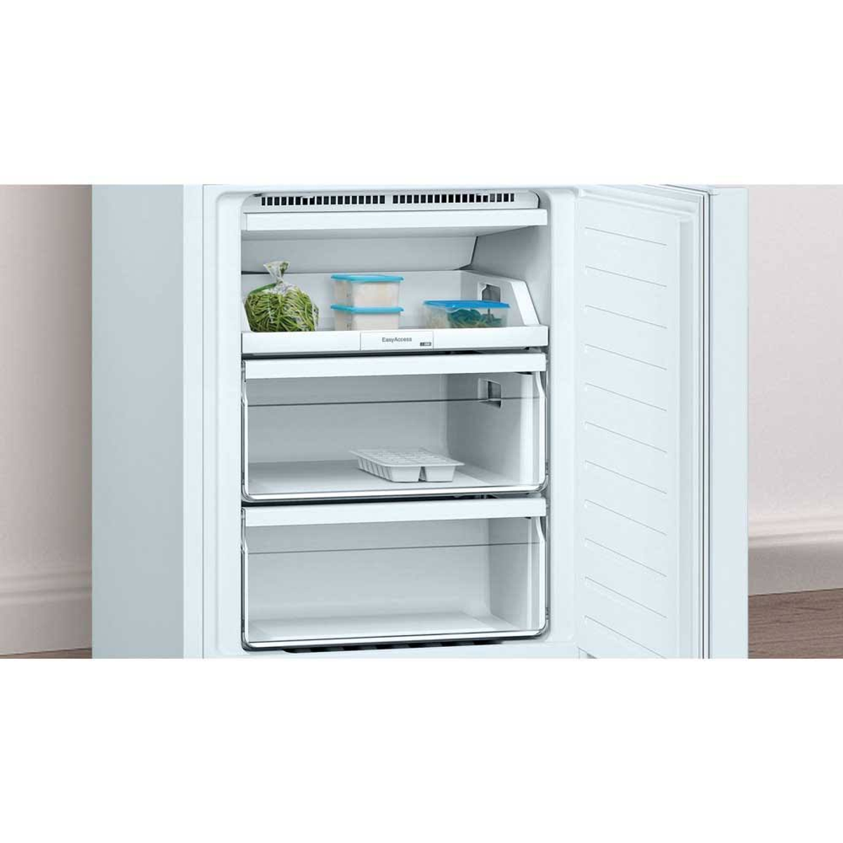 Interior de refrigerador con estantes, cajones y alimentos, interior blanco, puerta abierta y exterior blanco.