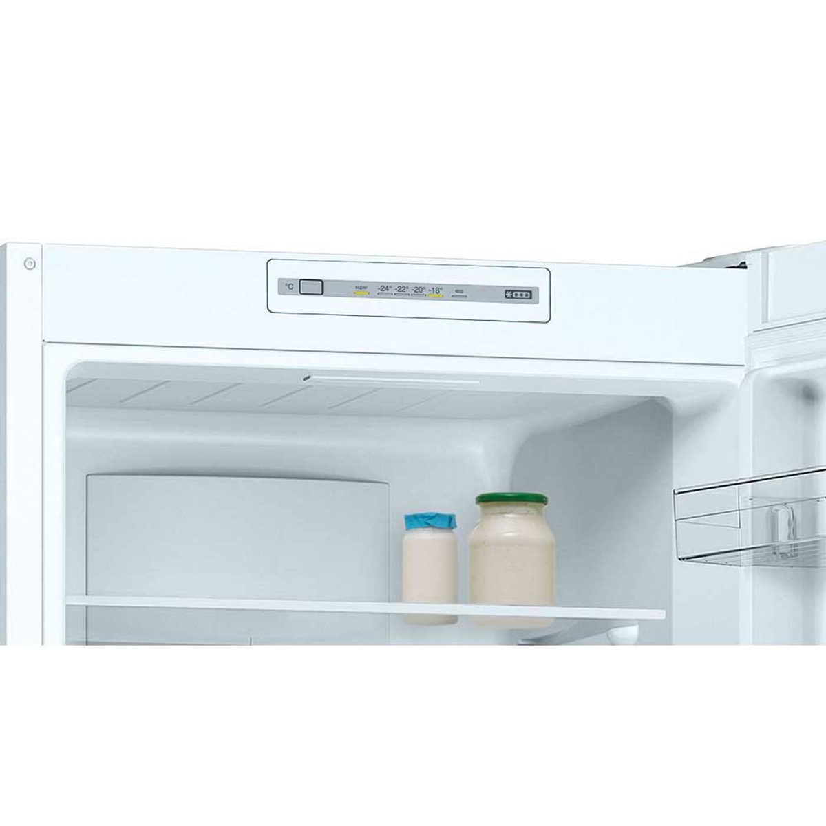 Interior de refrigerador con frascos y ajustes de temperatura en la parte superior.