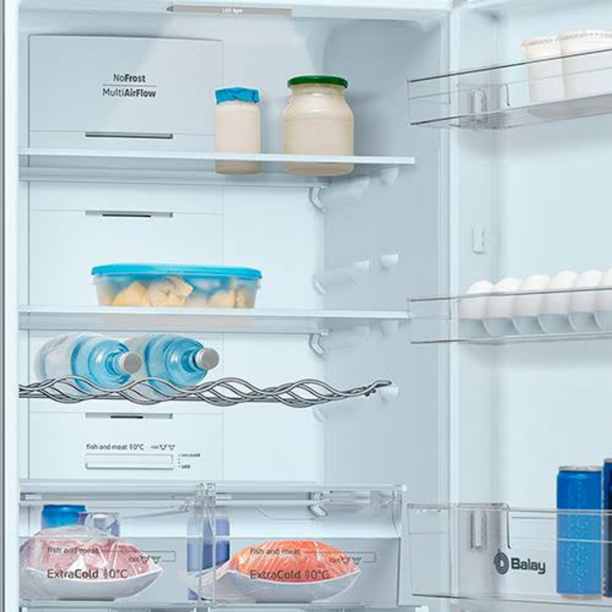 Dentro del refrigerador, frascos y recipientes con comida.