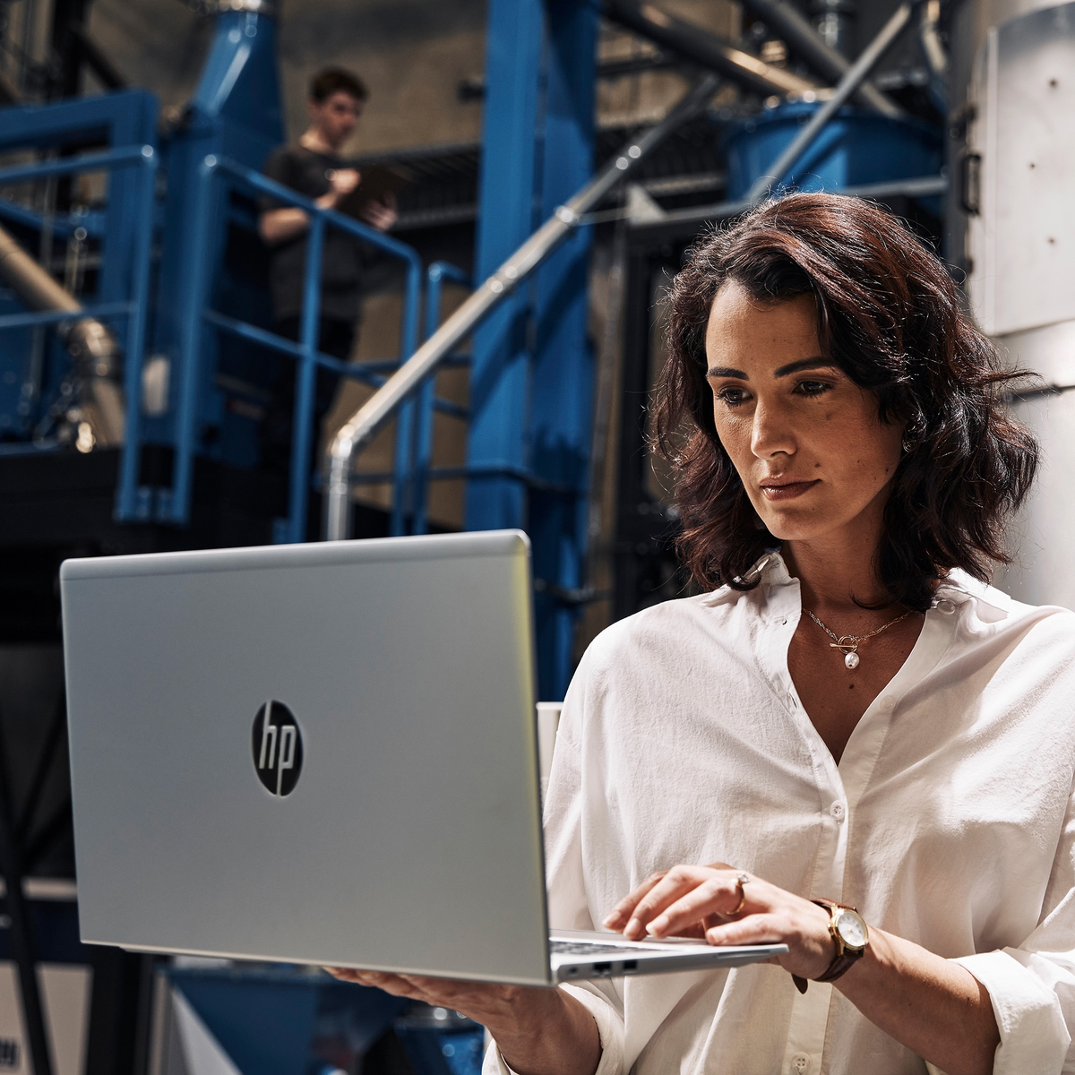Mujer con portátil, trabajando en un entorno tecnológico.