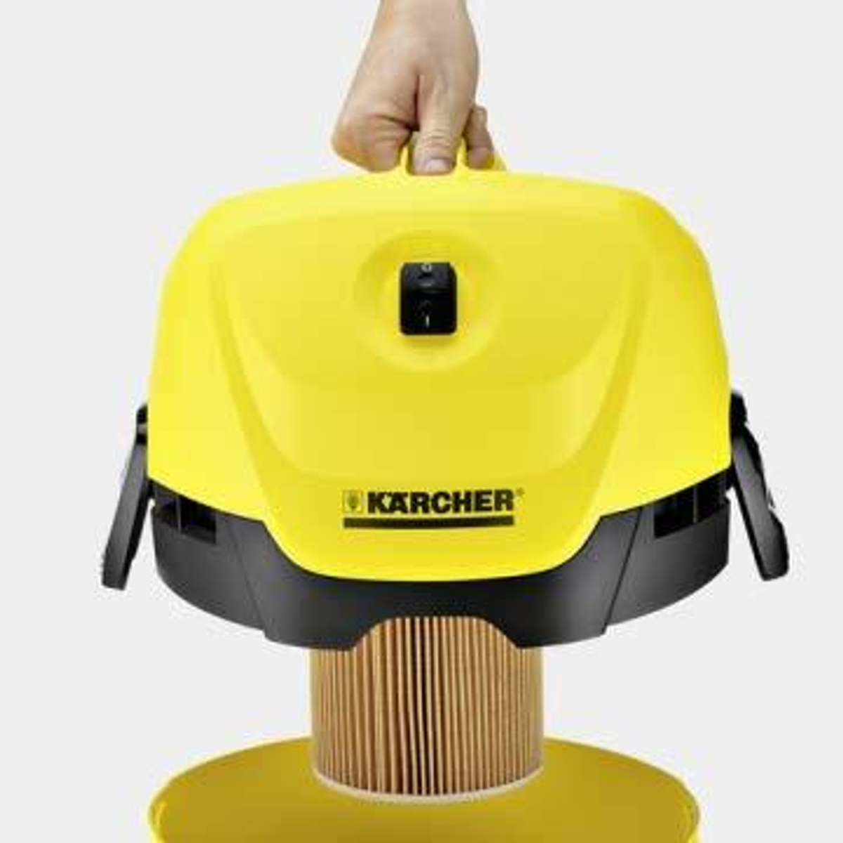 Ein gelber Kärcher Staubsauger, der von einer Hand gehalten wird. Er hat einen Filter und einen Griff.