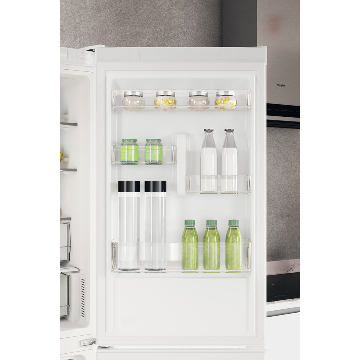 Refrigerador abierto con estantes que contienen frascos, botellas y botellas verdes.