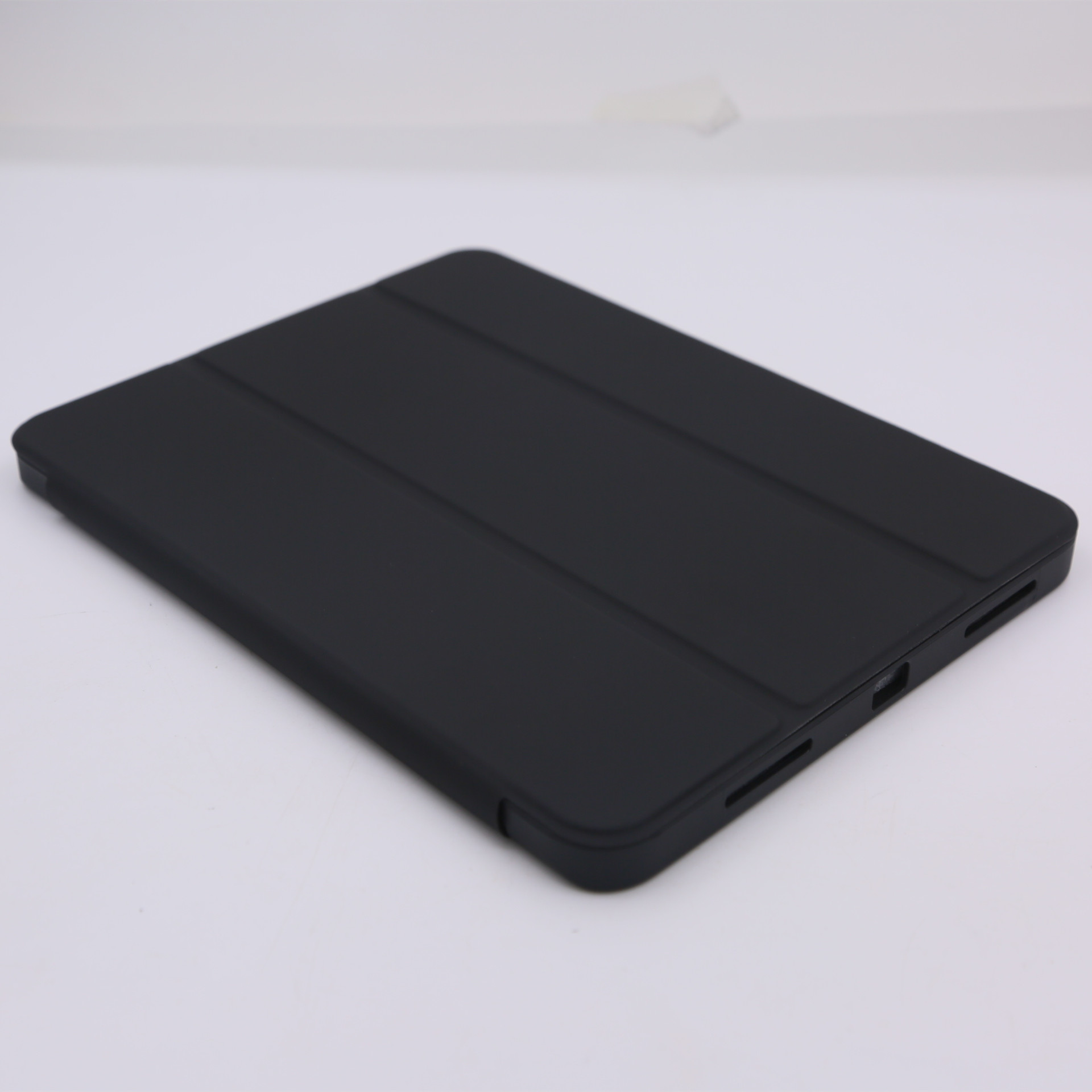 Custodia per tablet nera chiusa, su una superficie bianca.