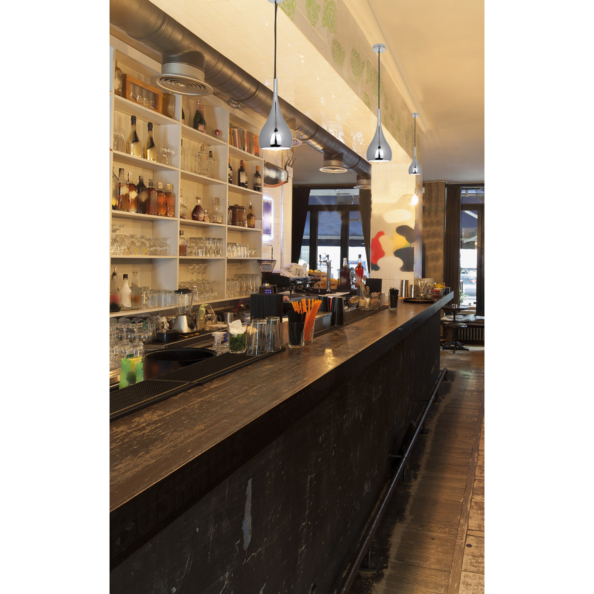 Eine Bar mit Hängelampen. Spirituosenflaschen und Gläser auf Regalen sind sichtbar. Die Bar ist dunkel.