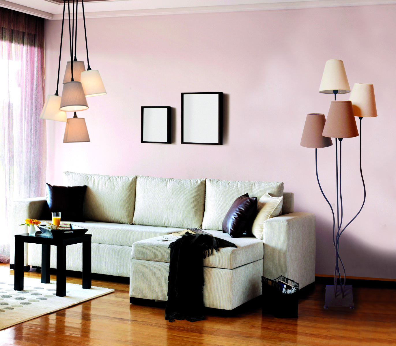 Ein Wohnzimmer mit weißem Sofa, schwarzem Beistelltisch und Stehlampe. Die Wand ist hellrosa.