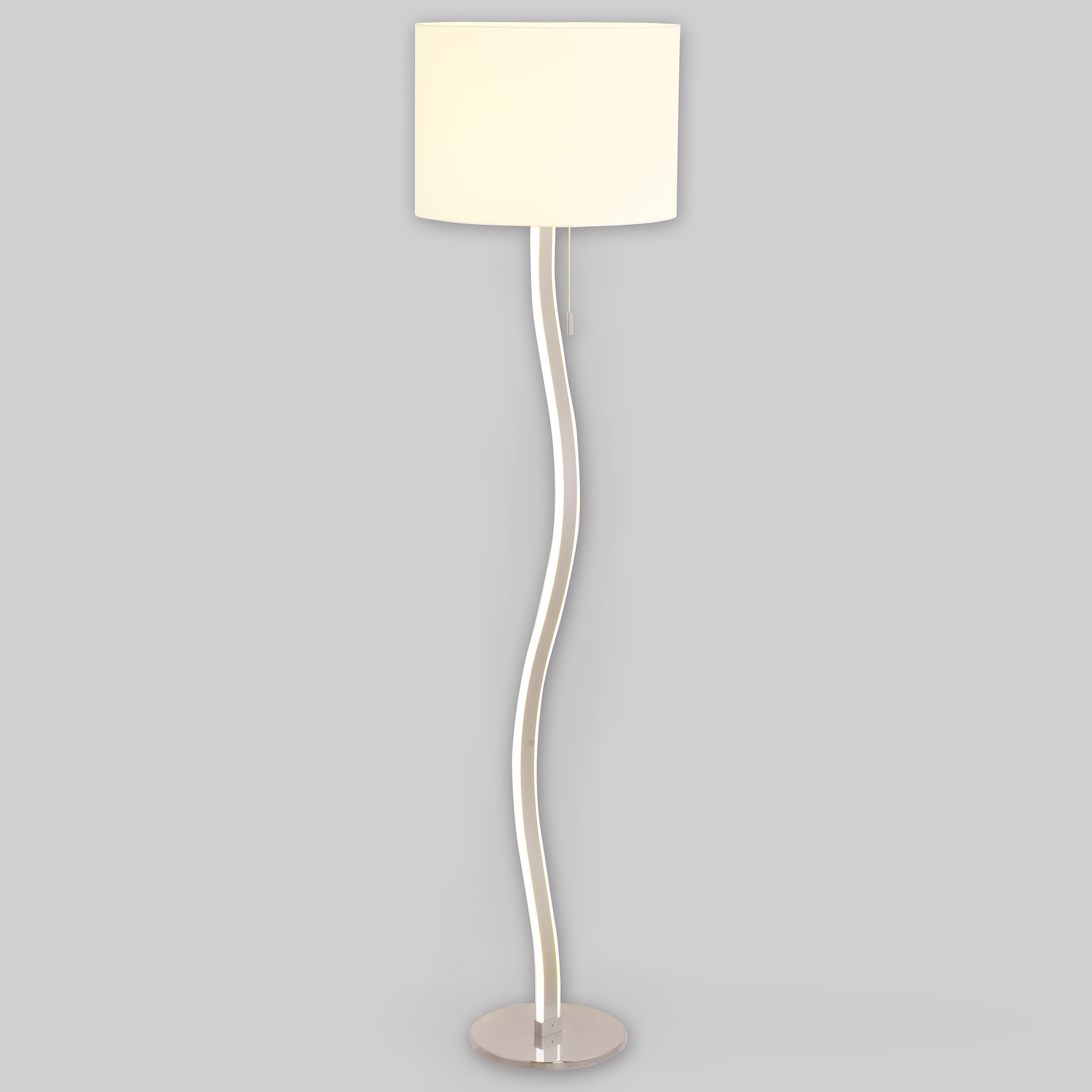 Eine hohe, silberne Stehlampe mit gebogenem Stiel und weißem, zylindrischem Lampenschirm.