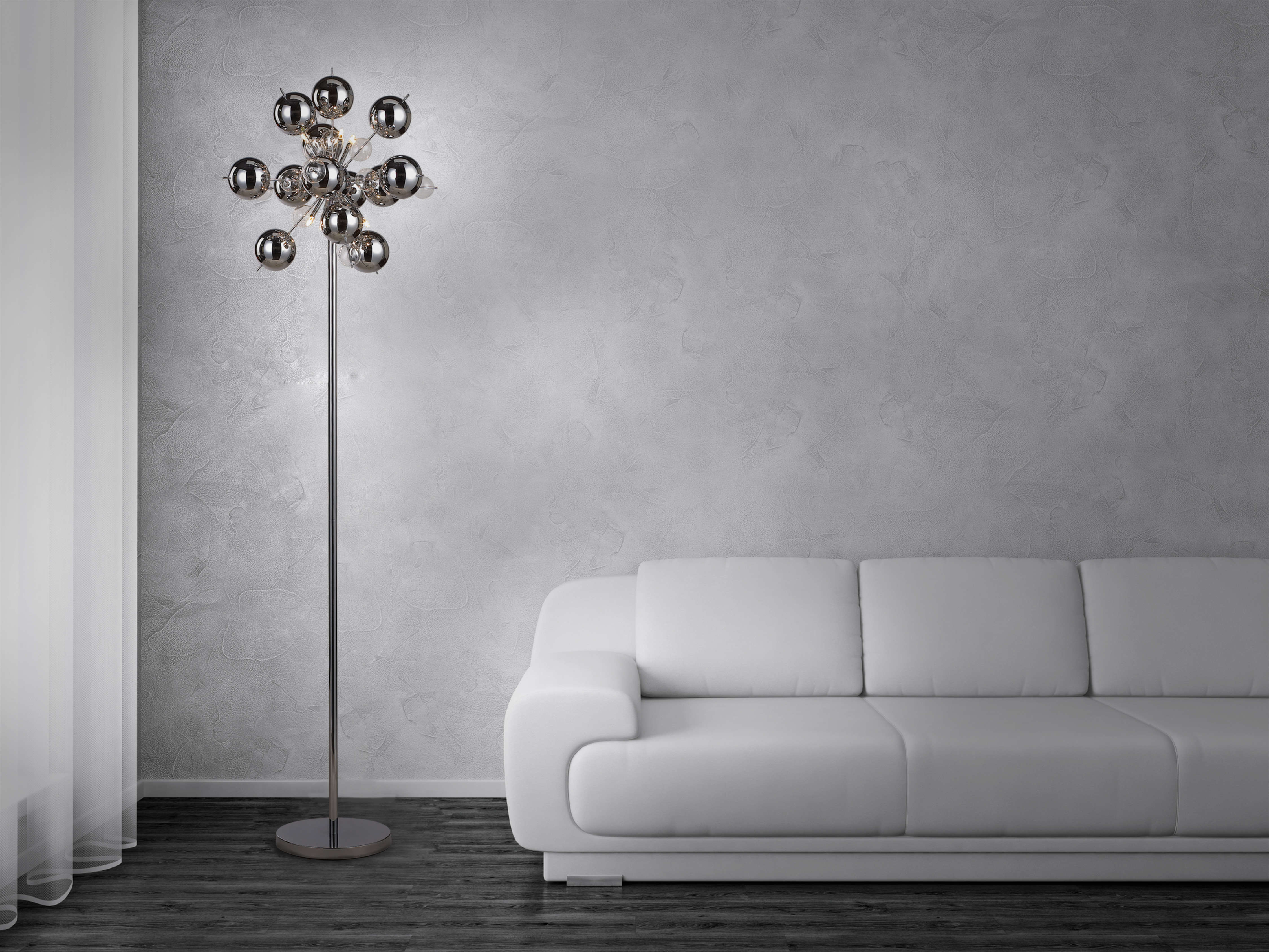 Moderne Stehlampe mit mehreren silbernen Kugeln auf einem silbernen Pfosten, weißes Sofa.