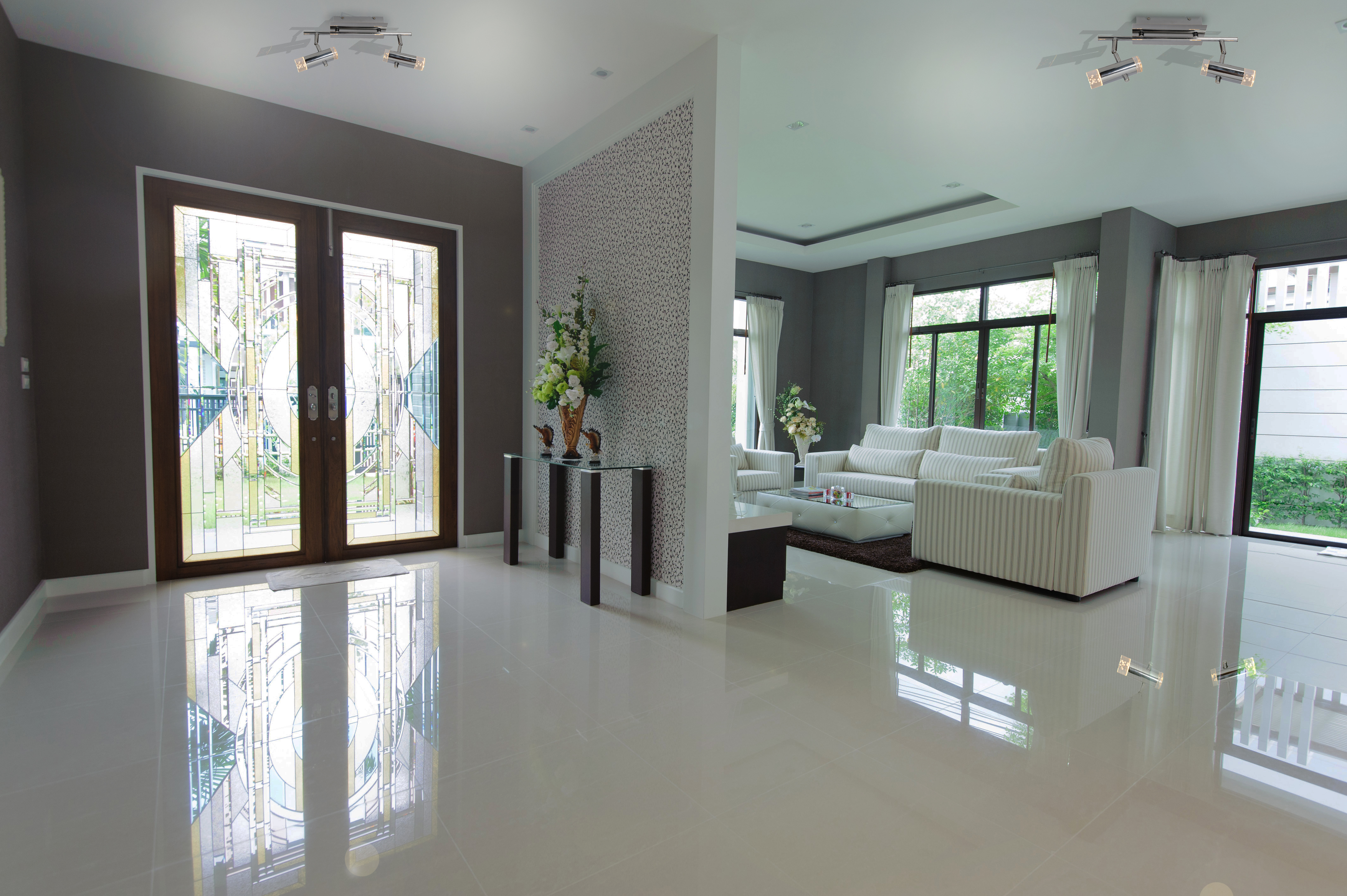 Ein helles, geräumiges Wohninterieur mit weißen Möbeln und großen Fenstern.