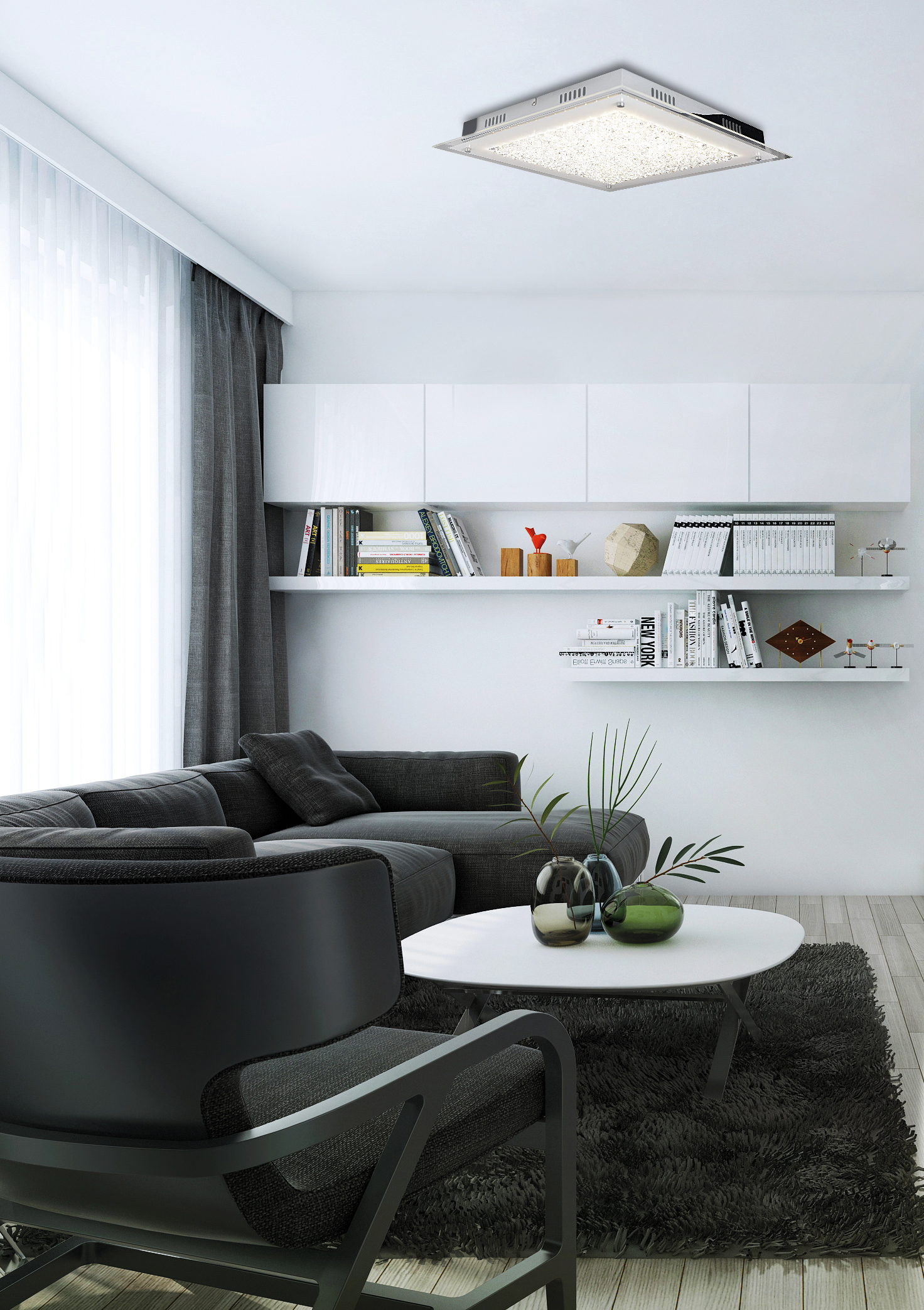 Ein modernes Wohnzimmer mit weißen Wänden, schwarzen Möbeln und einer Leuchte an der Decke.