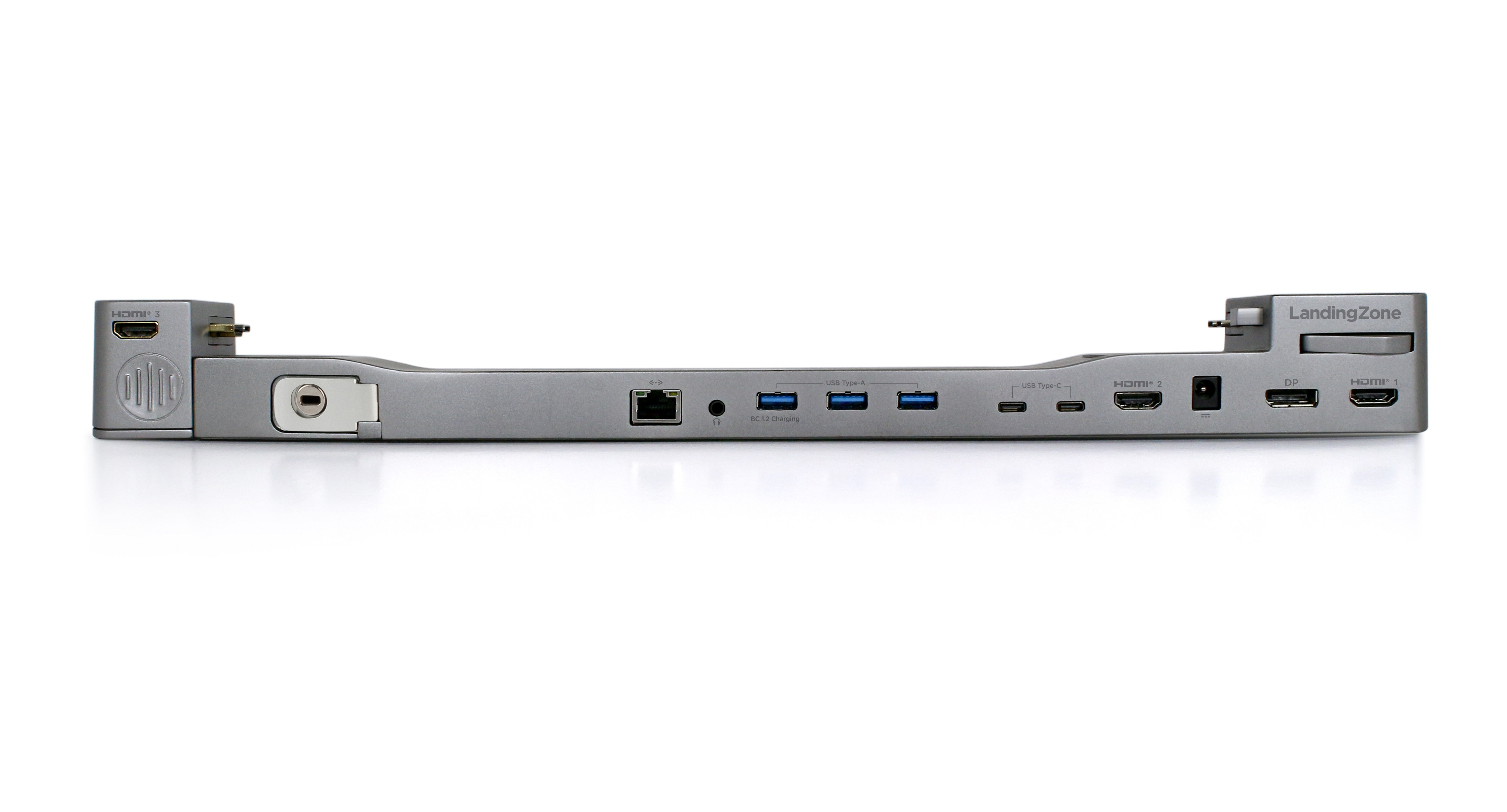Silberne Dockingstation. Mehrere Anschlüsse sichtbar. HDMI, USB und andere Anschlüsse. Weißer Hintergrund.