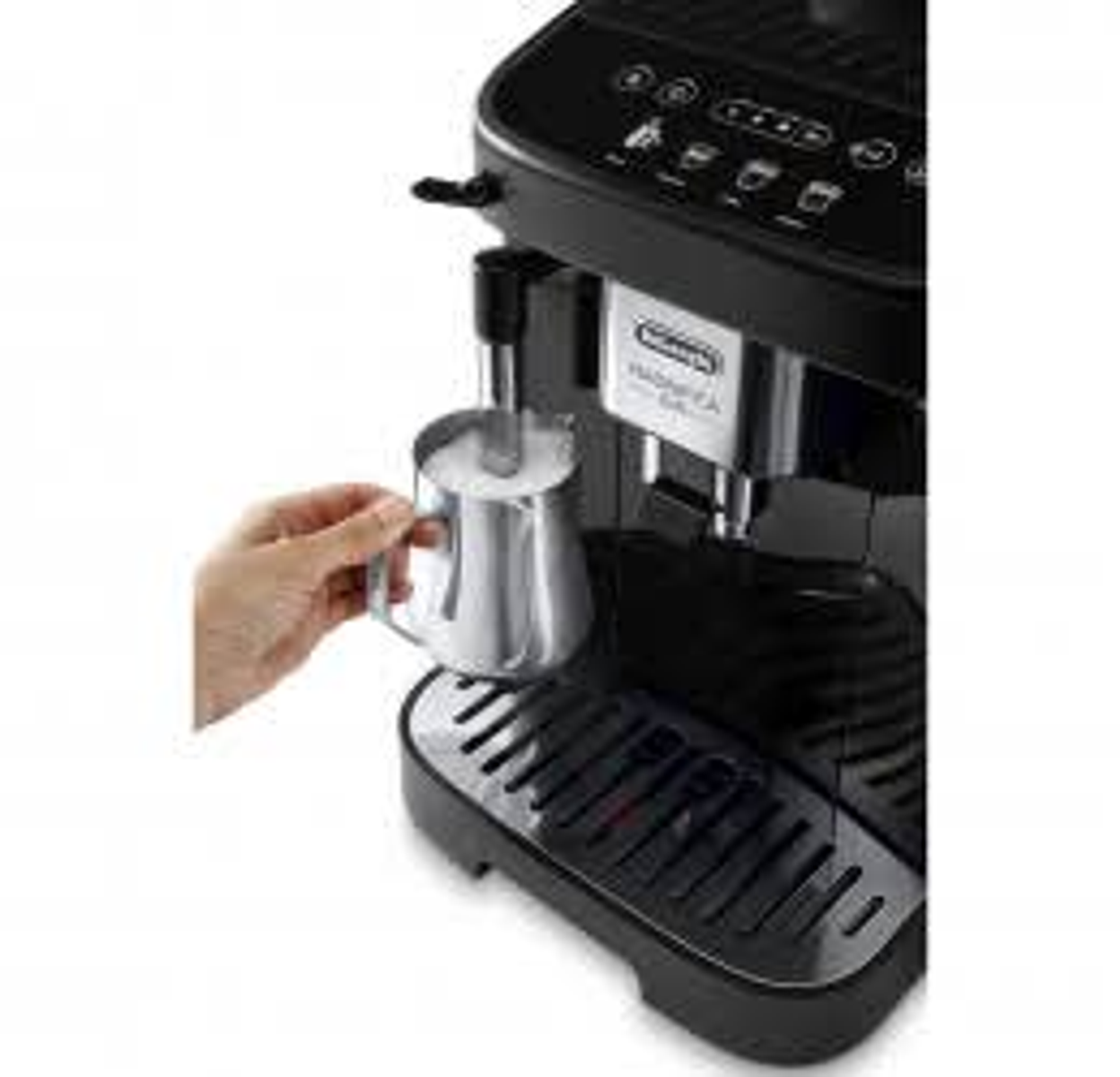 A black coffee machine with a hand holding a metallic milk jug.