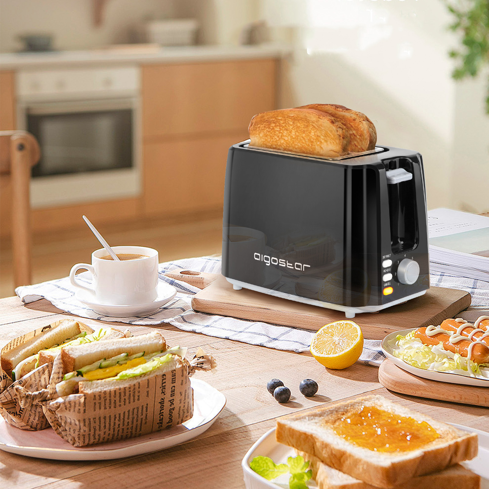 Schwarzer Toaster mit Toast darin, neben einem Tisch mit Essen und Utensilien.